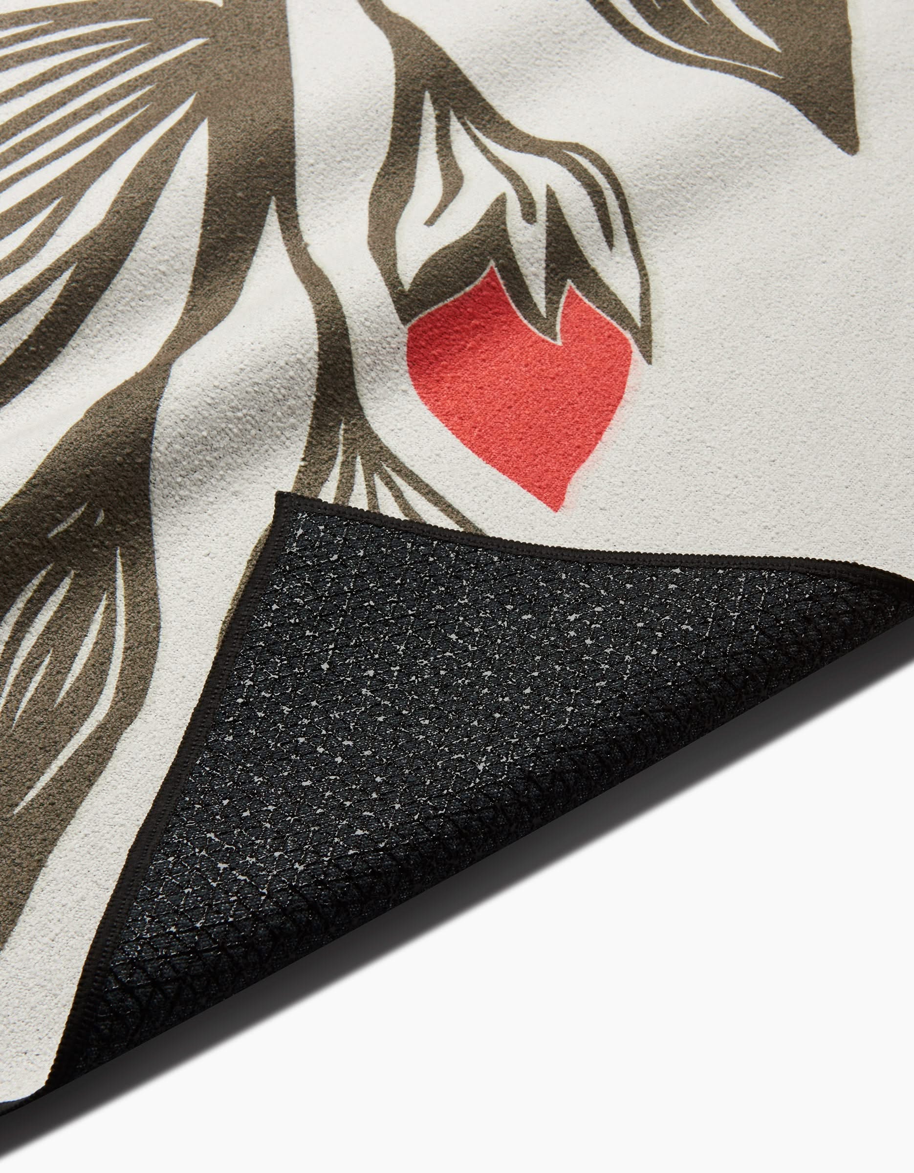 A close-up of Ash Cascades Flora Stamp mat shows its abstract brown and white leaf design with a red accent on a light background. The folded corner reveals the black textured non-slip backing made from recycled materials.