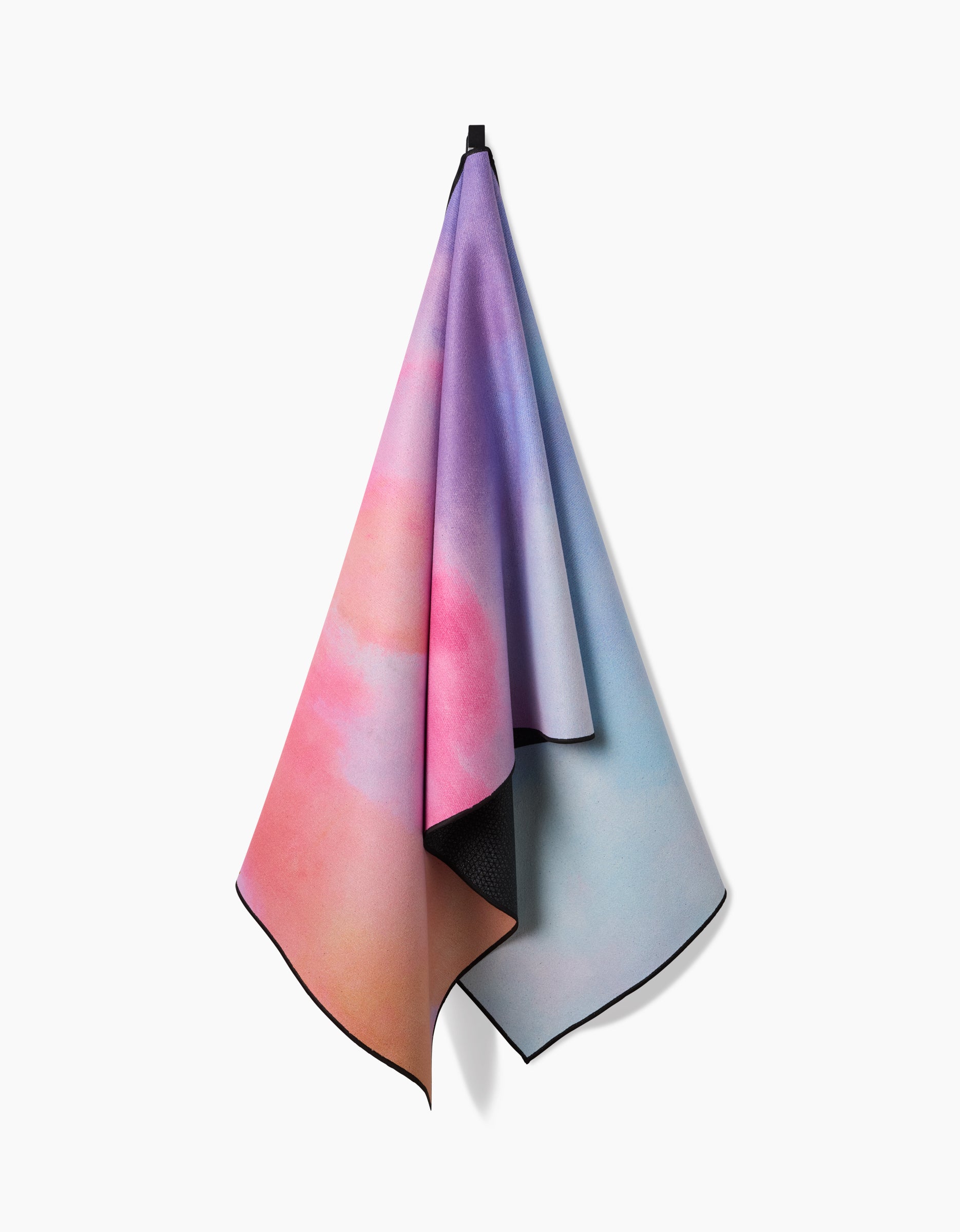 The Magic in the Sky yoga towel by Stefanie Bales features soft pink, purple, and blue gradients, hangs from a black loop against a white background, and is crafted from recycled materials.