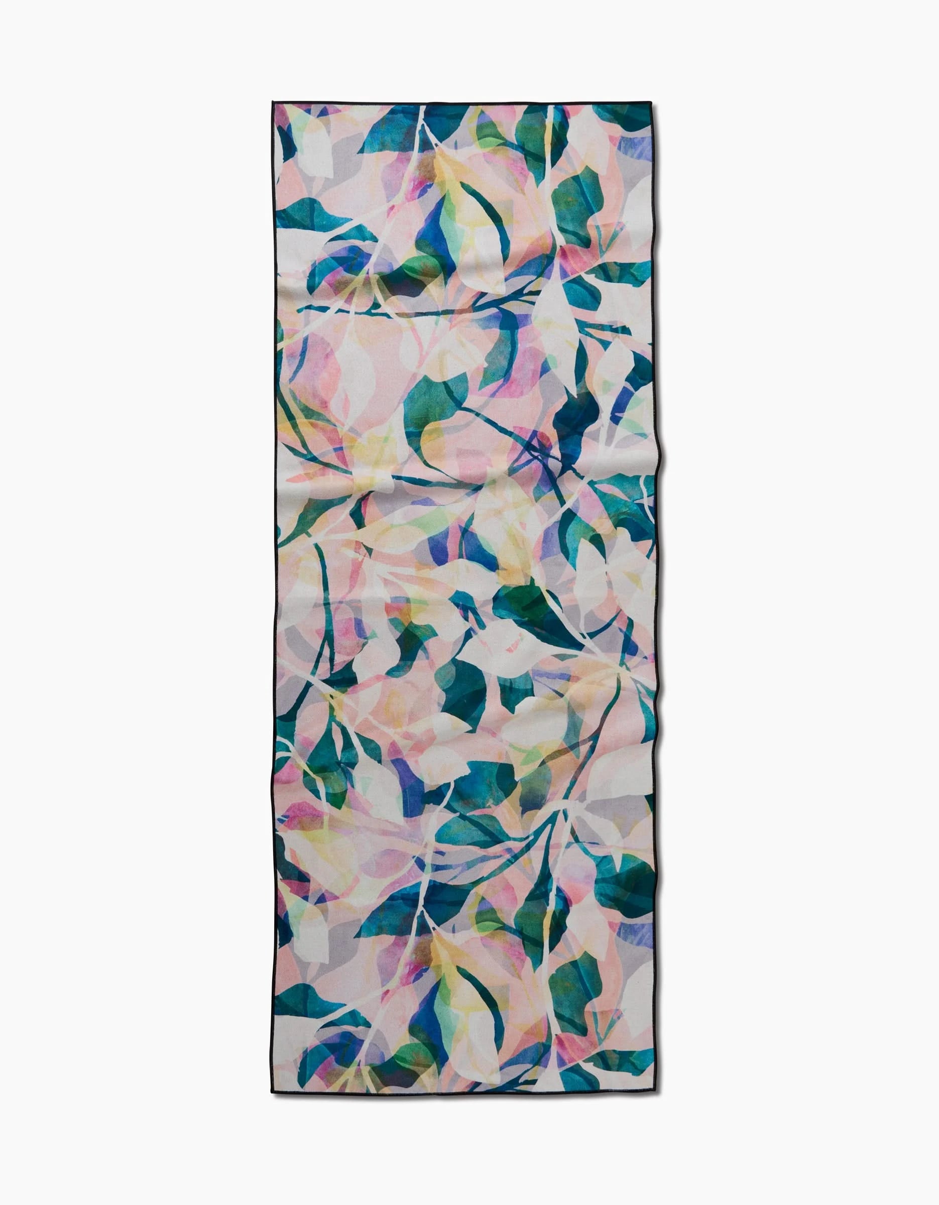 Painted Foliage by Rachel Parker is a rectangular scarf featuring a vibrant abstract leaf pattern in blue, green, yellow, and pink on a light background. Made from post-consumer recycled materials and shown flat against a white surface.