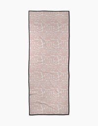 The Pink Scandi Flowers yoga towel by Katie OShea is rectangular, light pink with a white symmetrical floral pattern and a thin black border, shown flat on a white background.