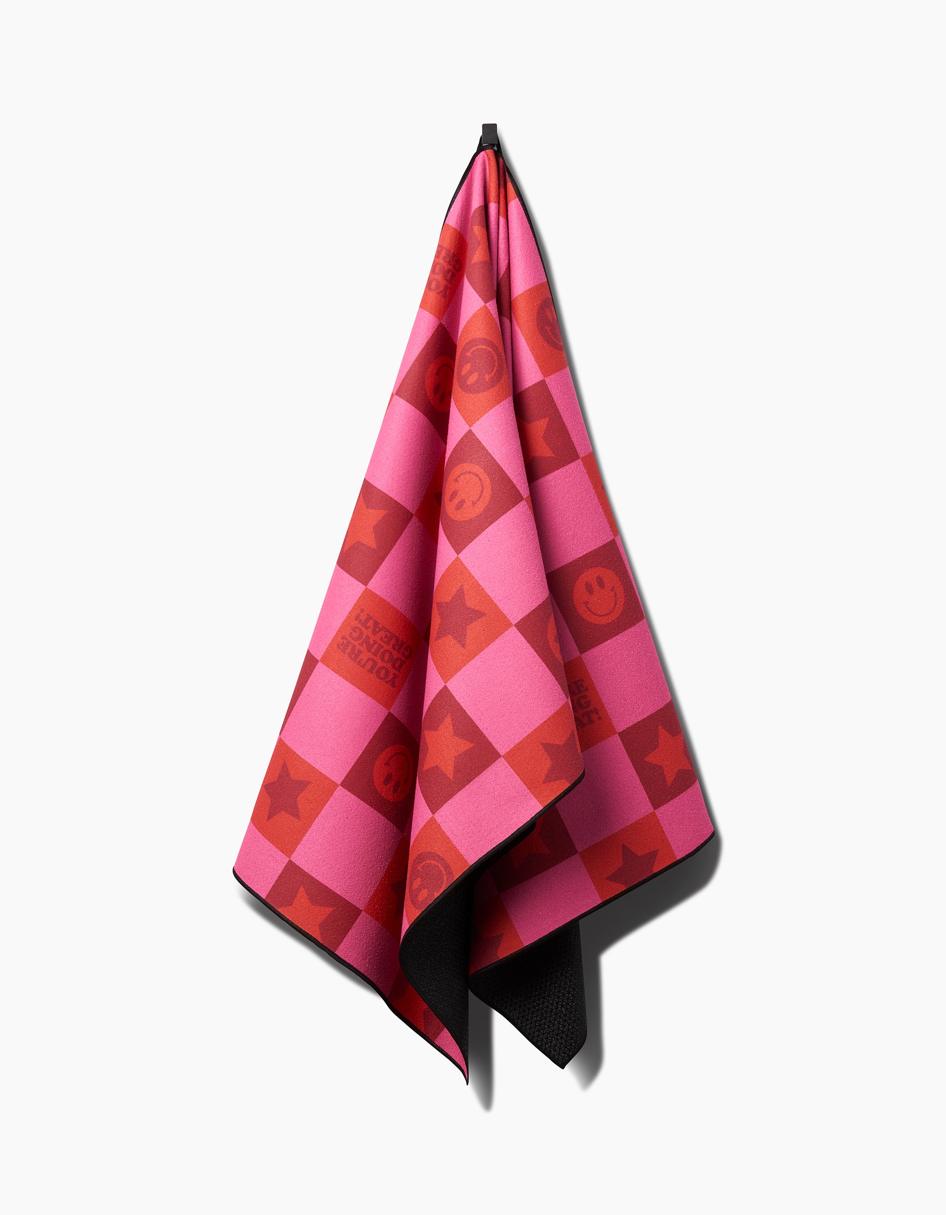 The Youre Doing Great yoga towel by Quotes by Christie features pink and red checkered squares with smiley faces, stars, and text. Made from recycled materials, its playful pattern stands out against a white background.
