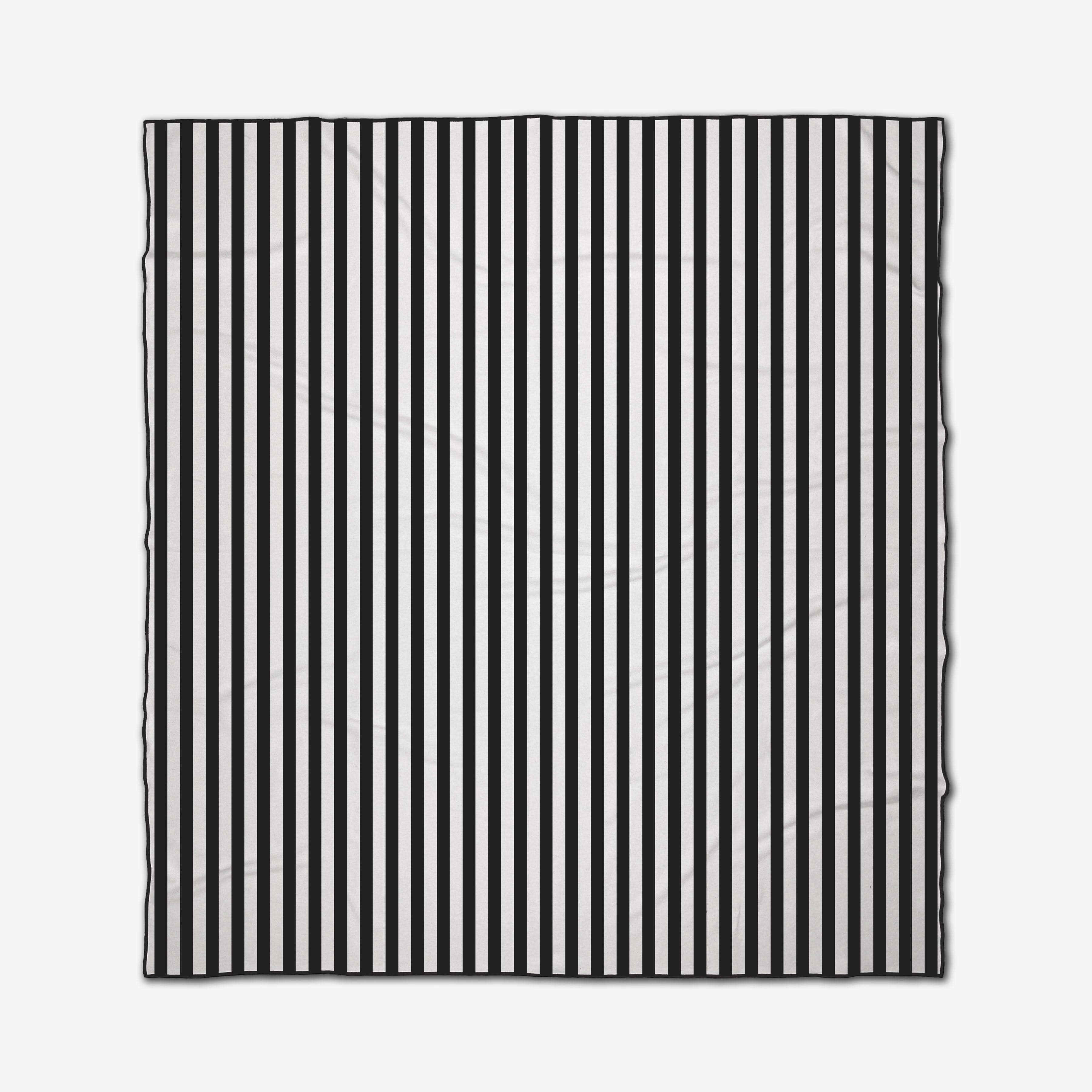 The GEOMETRY Black Stripes is a square recycled beach blanket with evenly spaced vertical black and white stripes, slightly wrinkled and shown against a white background.