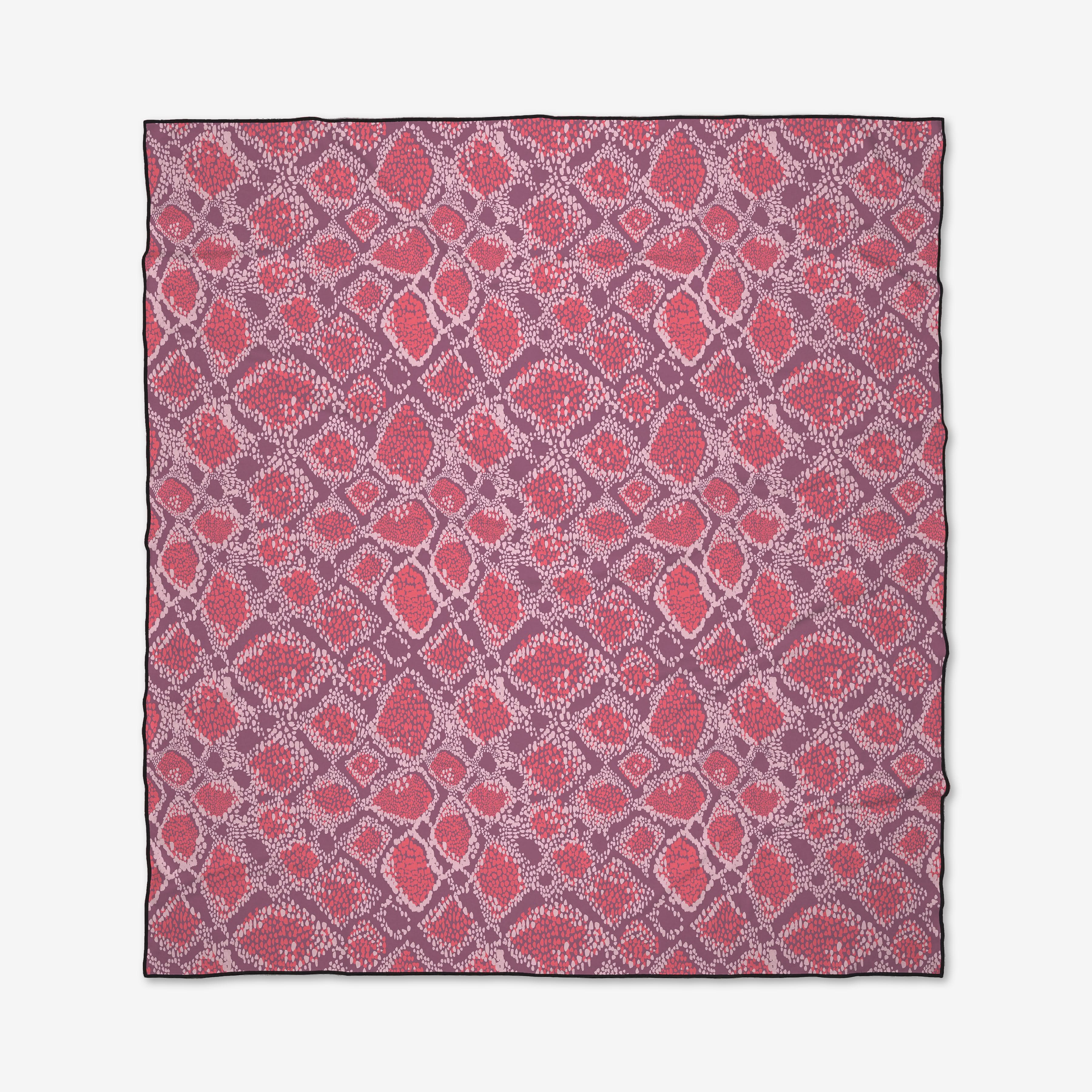 The Elisabeth Wing Vibrant Venom Micro-loop Beach Blanket is square, quick-drying, and made from recycled materials. It features a geometric pattern of red, pink, and purple diamonds and ovals on white with black edges.