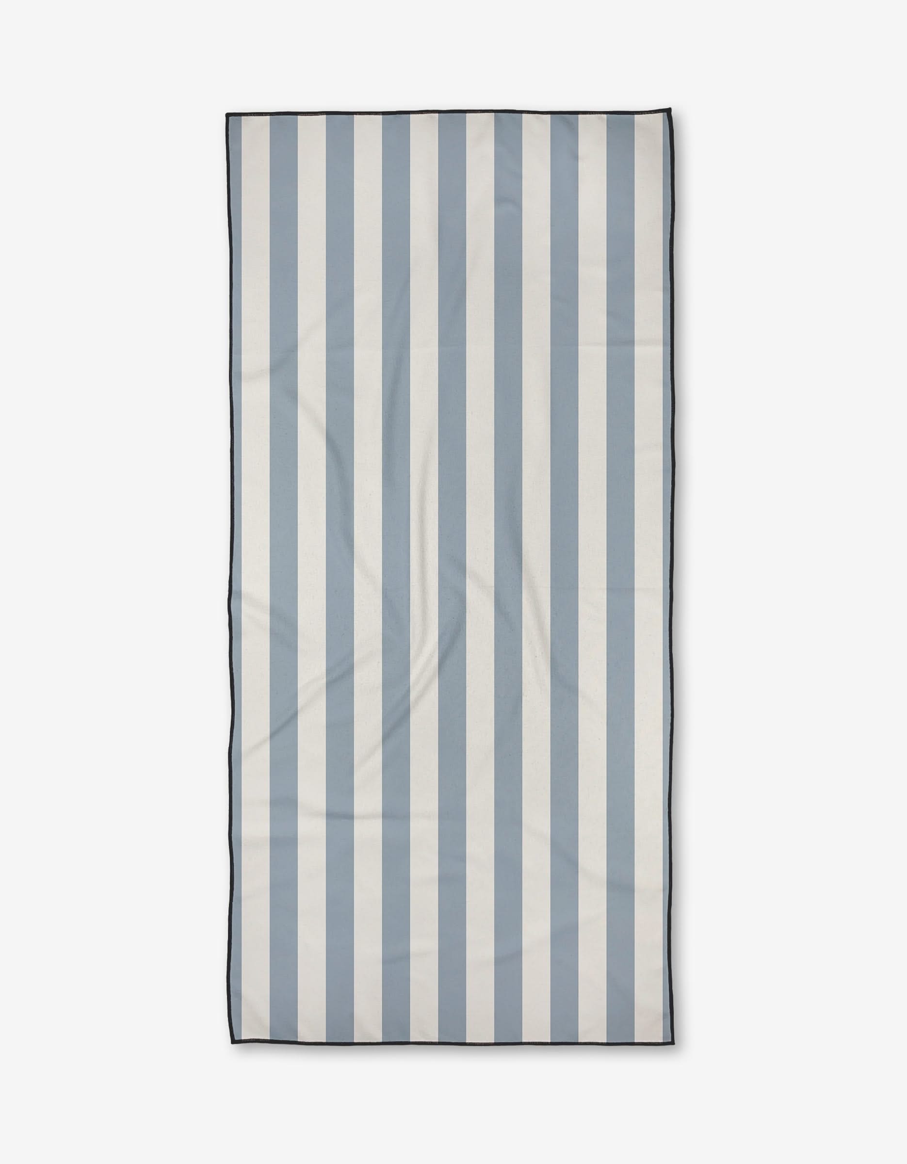 The Becki Owens Julia towel, a rectangular ultra-absorbent piece with vertical light blue and white stripes and a thin dark border, is shown laid flat on a plain white background.