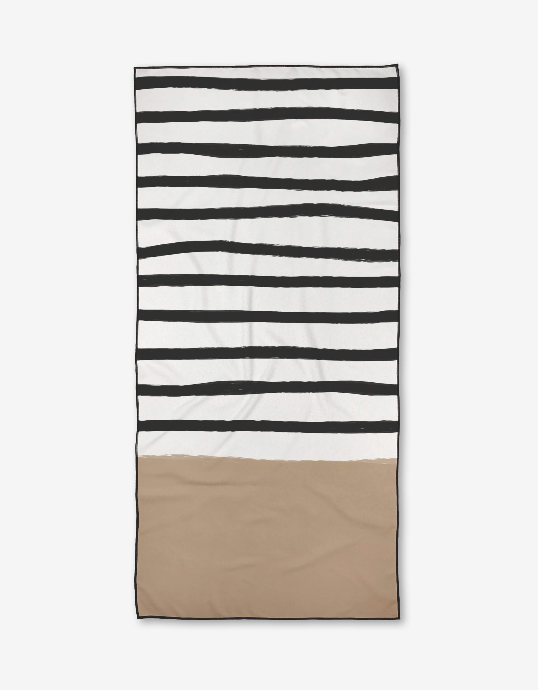 The Kails beach towel by Kailee Wright features uneven black stripes on white at the top and a solid beige bottom. Made from recycled materials, it is quick-drying and convenient for your beach days.