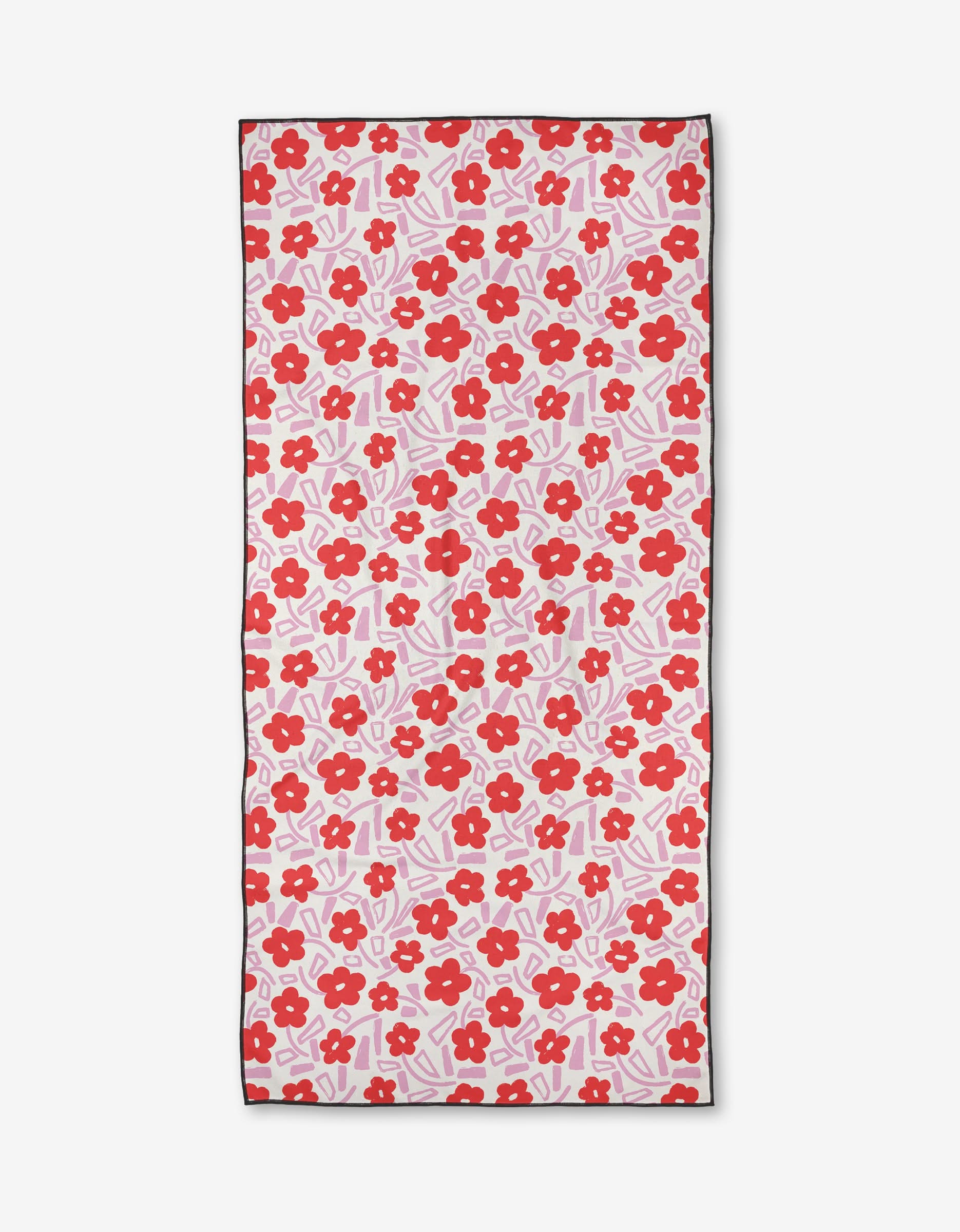 The Pink Wild Garden beach towel by Happy Hemera features red flowers and pink leaves on white. Made from quick-drying, recycled materials, it’s finished with a thin black border for a stylish touch.