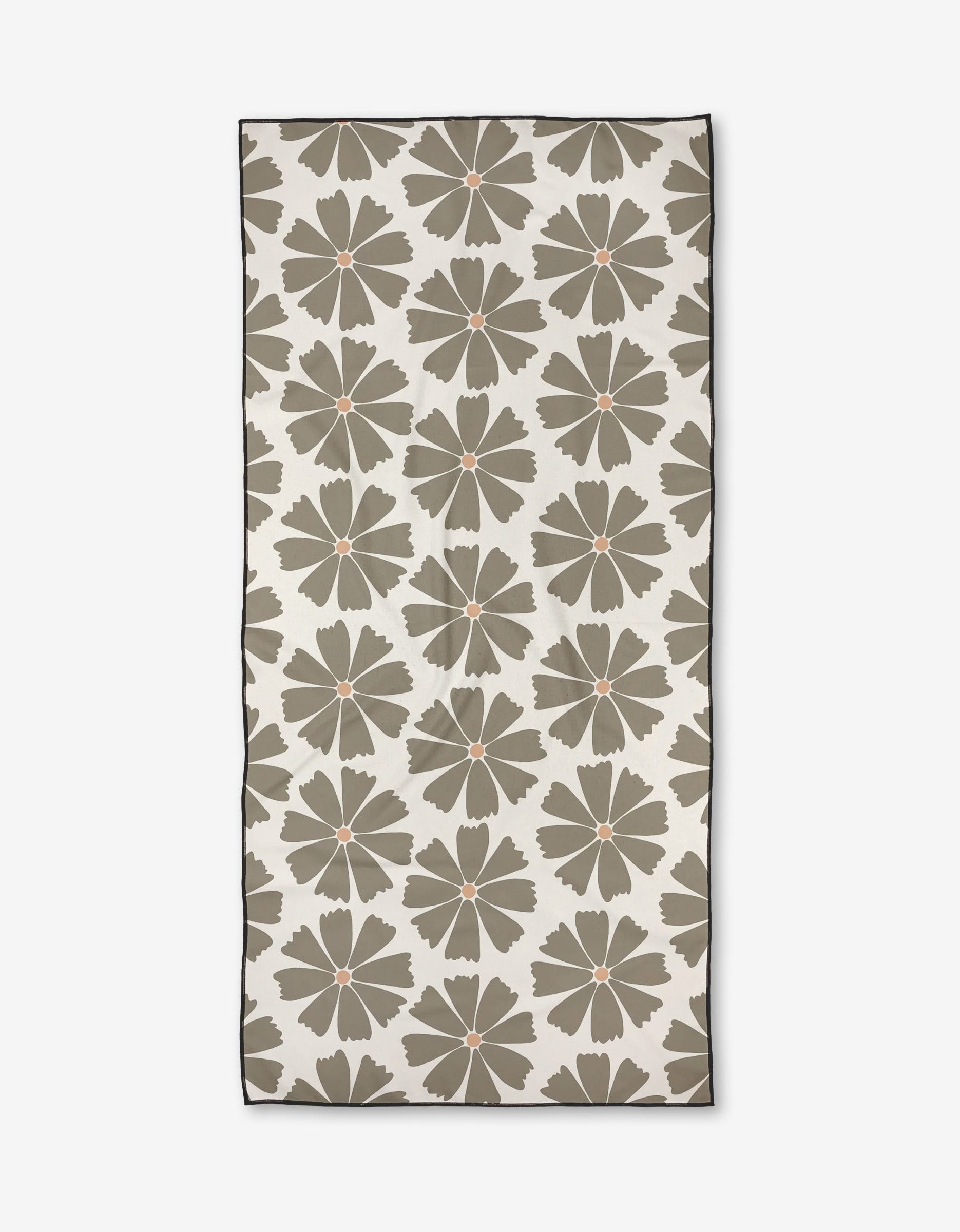 The Hufton Studio Retro Daisy is a rectangular beach towel made from recycled materials, featuring large olive green flowers with orange centers on an off-white background, a thin dark border, and soft micro-loop texture.