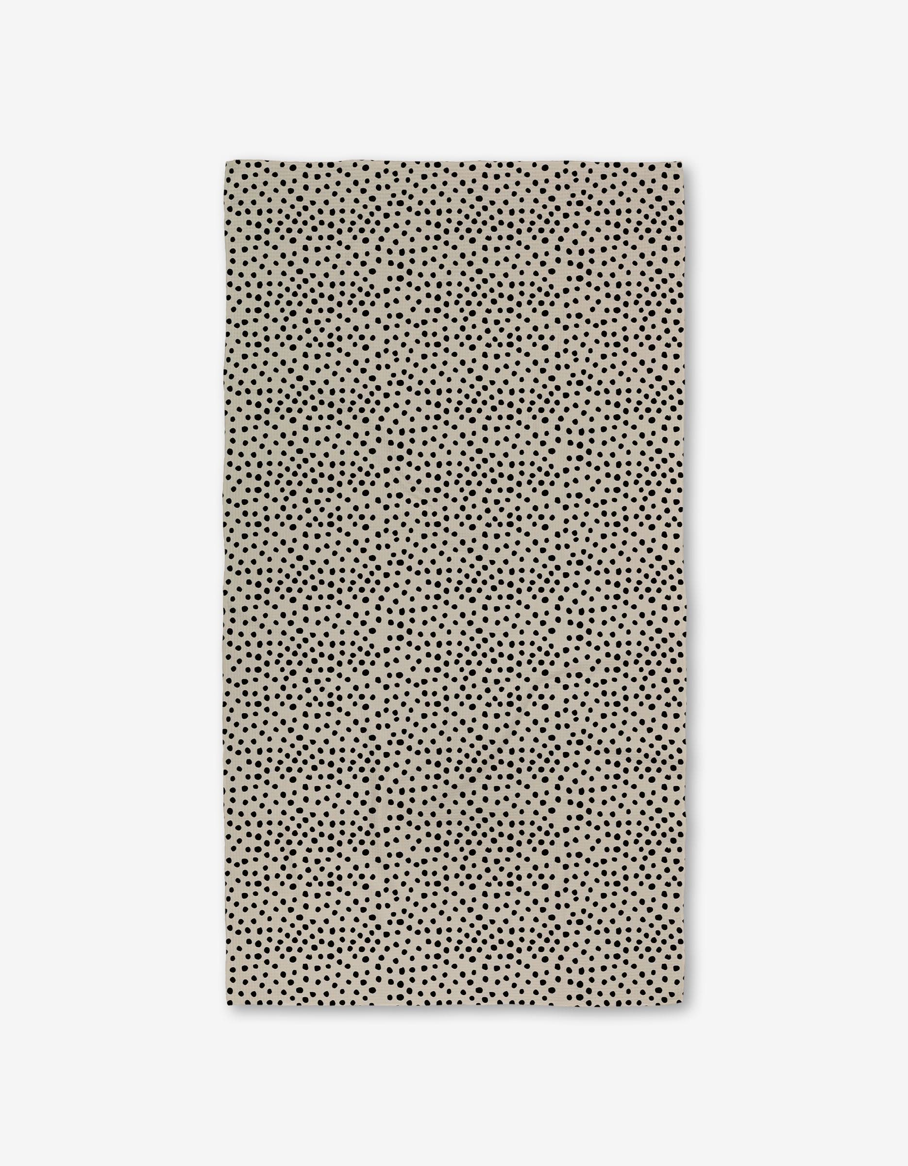The GEOMETRY Dotty Tan is a rectangular beige napkin with small, evenly spaced black dots, crafted from ultra-absorbent Geoweave fabric and shown flat on a white background.