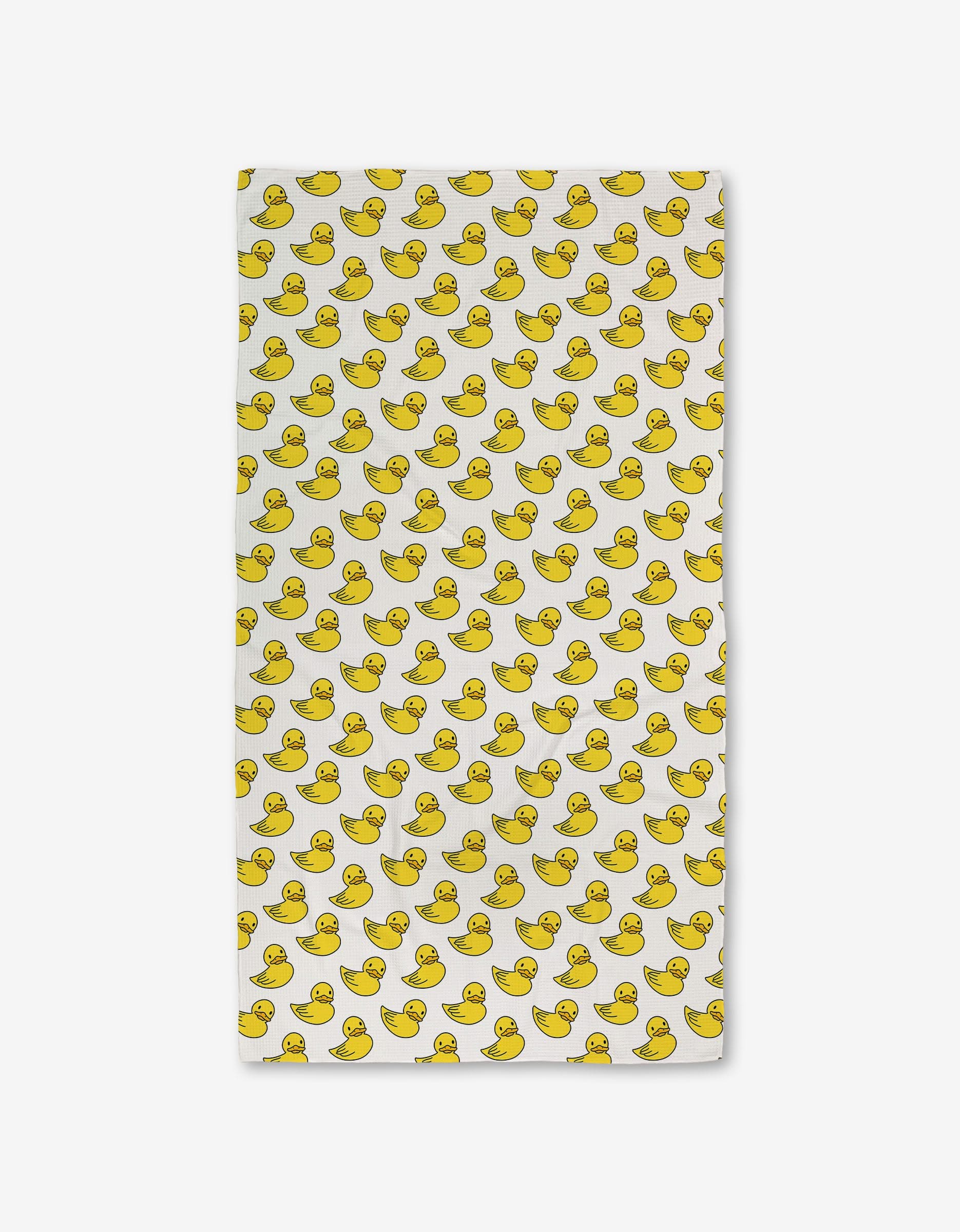 The GEOMETRY Duckies Luxe Bath Towel is a white rectangular towel with a playful yellow rubber duck pattern, crafted with ultra-absorbent Geoweave technology for soft and efficient drying.