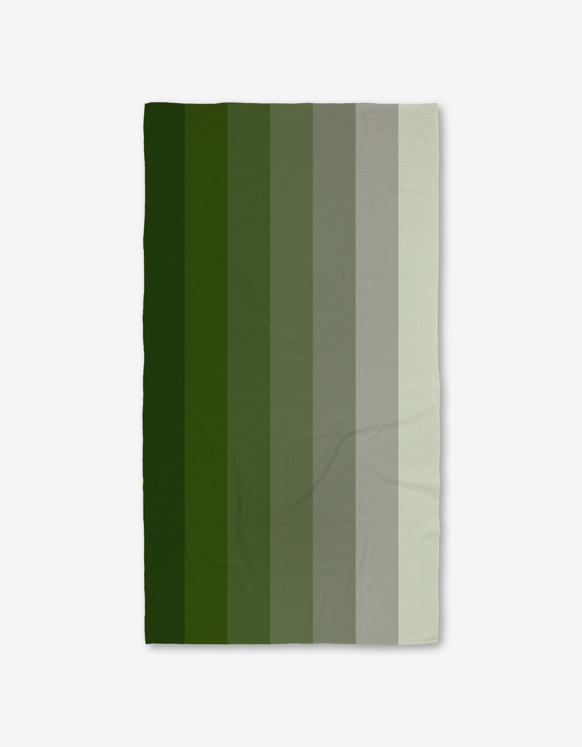 The GEOMETRY Grassy Levels Luxe Bath Towel features vertical green stripes that transition from dark to light and is ultra-absorbent thanks to advanced Geoweave technology.