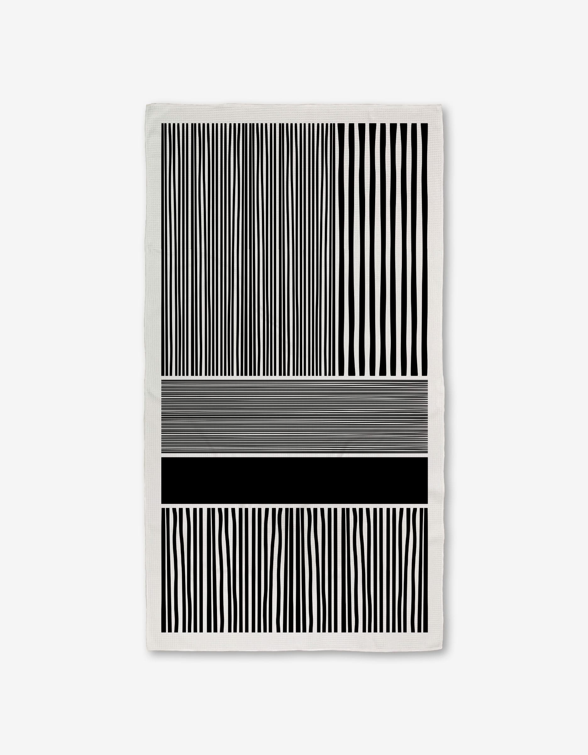 The Modern Form towel by GEOMETRY features Geoweave technology with black and white vertical stripes on the top and bottom, and abstract horizontal lines of varying thicknesses and shades in the middle for a modern look.
