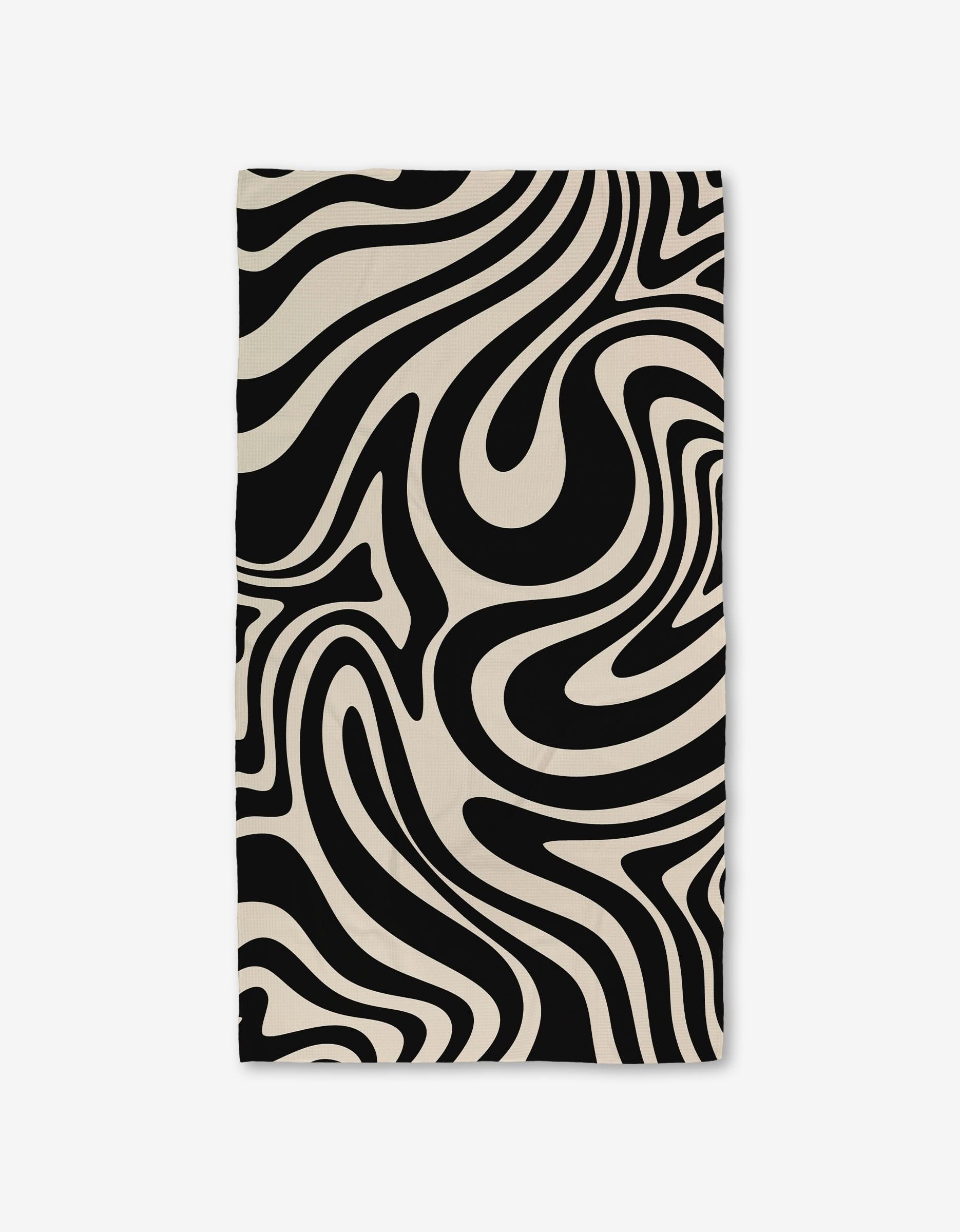 The GEOMETRY Rolling Retro Luxe Bath Towel showcases Geoweave technology and a bold black-and-white wavy zebra-stripe pattern, giving it a dynamic, modern look.