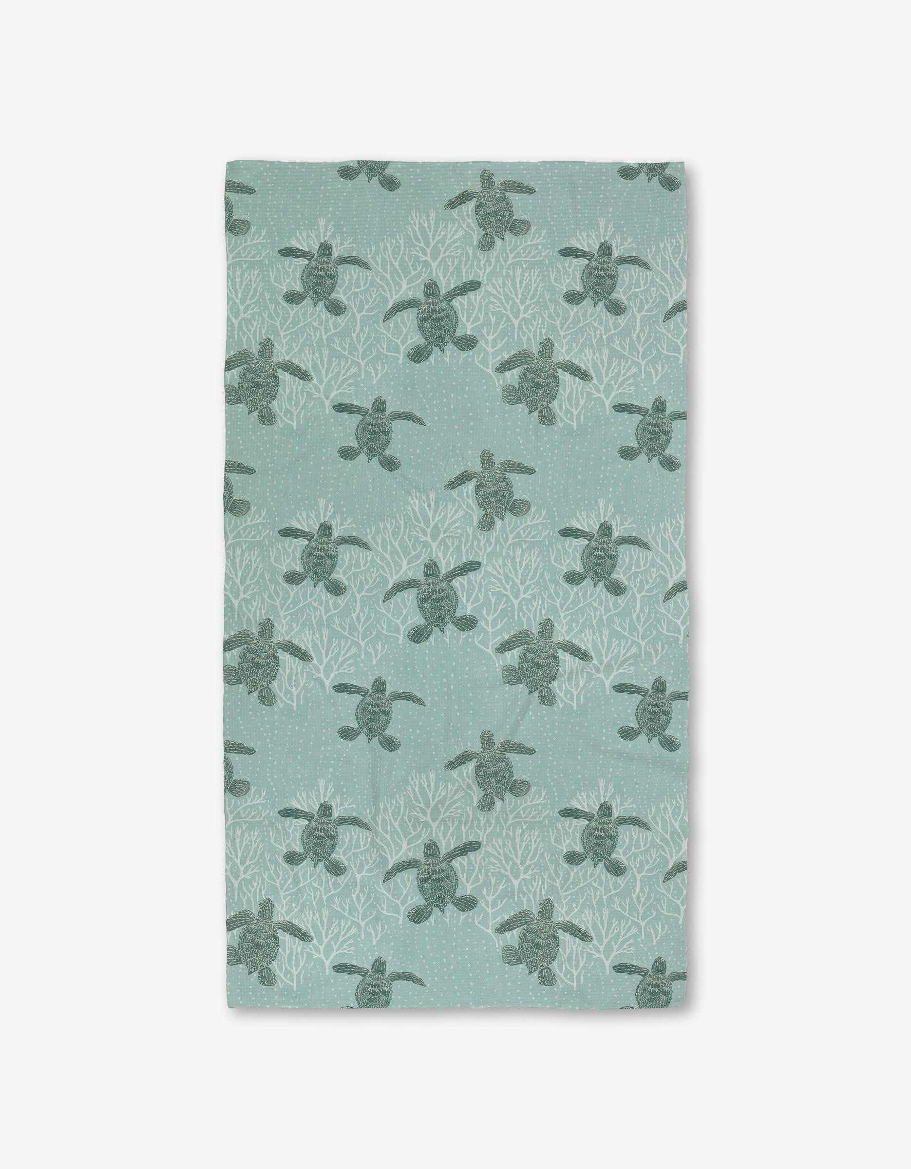 The Katie OShea Sea Turtles Luxe Bath Towel showcases sea turtles among white coral on a light teal background, made with Geoweave technology for an ultra-absorbent, premium feel.
