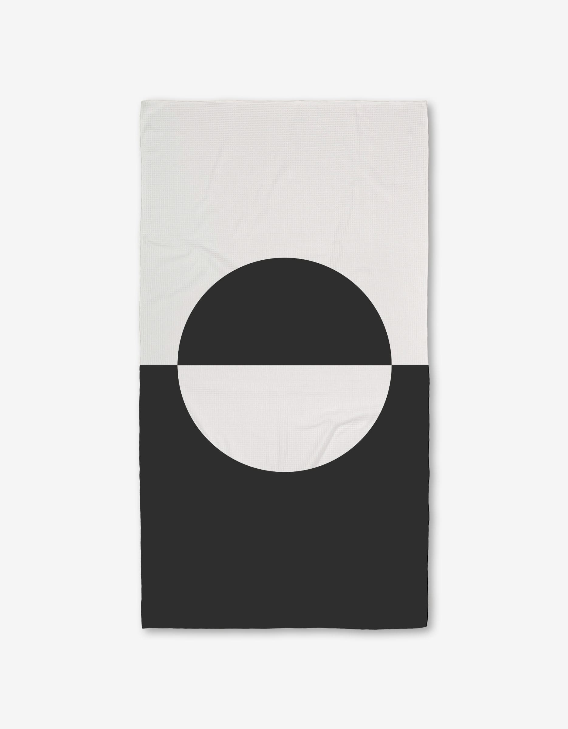 The GEOMETRY Yin Yang Bath Towel features a minimalist geometric design with a black semicircle on the white lower half, creating bold contrast, and is crafted with ultra-absorbent Geoweave technology.