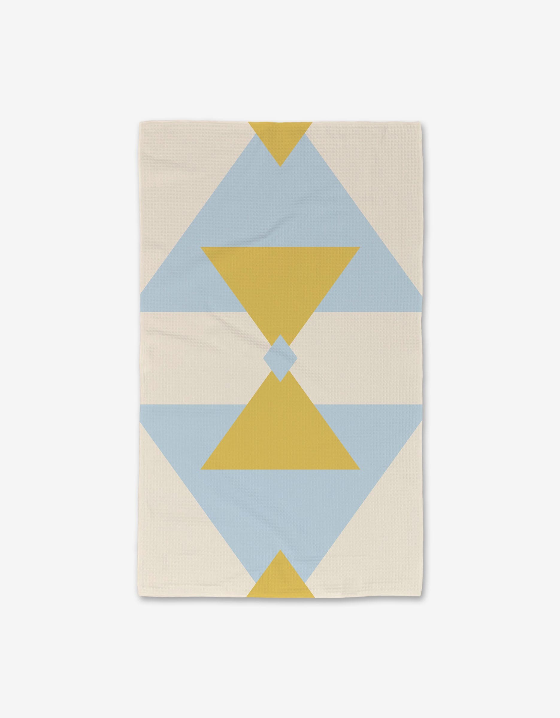 The Balanced Blue throw blanket by GEOMETRY features a modern geometric pattern with blue and yellow triangles and diamonds on a cream background, inspired by the quick-drying, ultra-absorbent Luxe Hand Towel fabrics for added comfort.