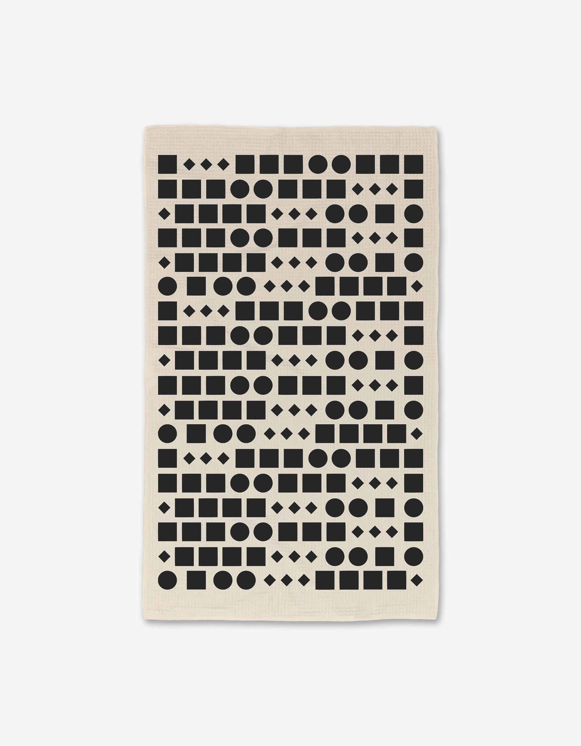 The GEOMETRY Coded Luxe Hand Towel features black geometric shapes in horizontal rows on a white, beige-accented background, crafted with ultra-absorbent Geoweave technology.