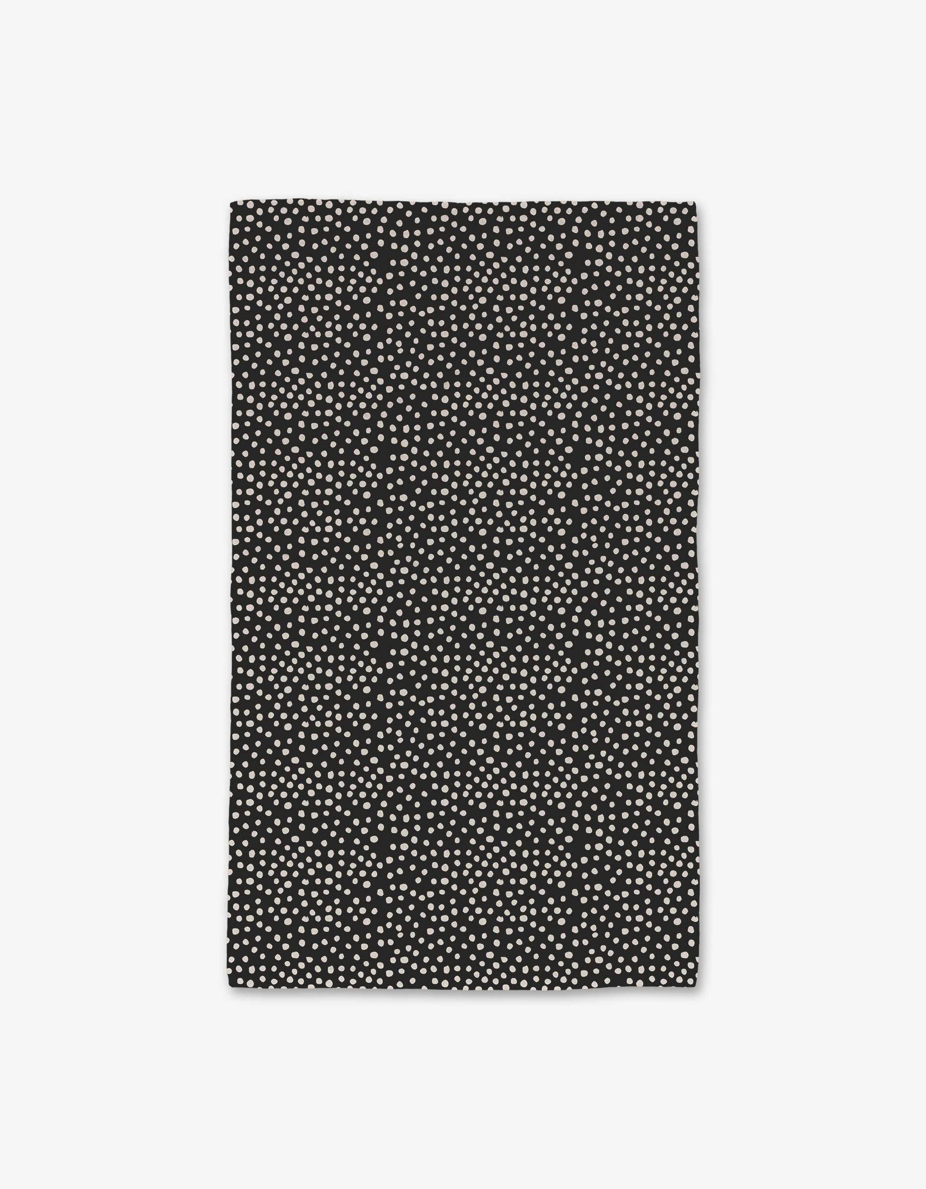 The GEOMETRY Dotty Black towel features a rectangular shape with small white dots on black, made with Geoweave technology for ultra-absorbency. Shown against a plain white background.