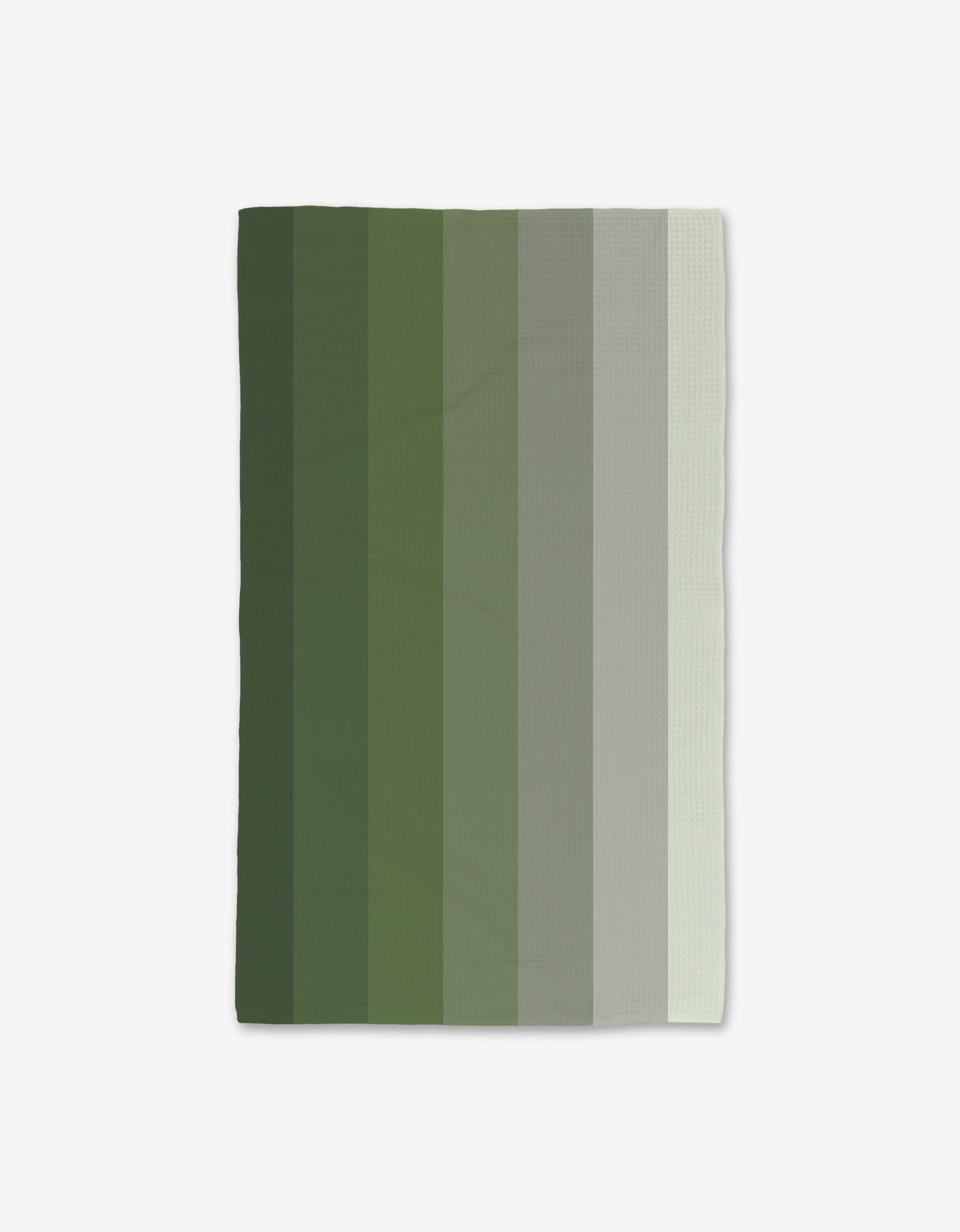The GEOMETRY Grassy Levels blanket features vertical green stripes from dark to light, is made with recycled materials, and is shown on a white background.