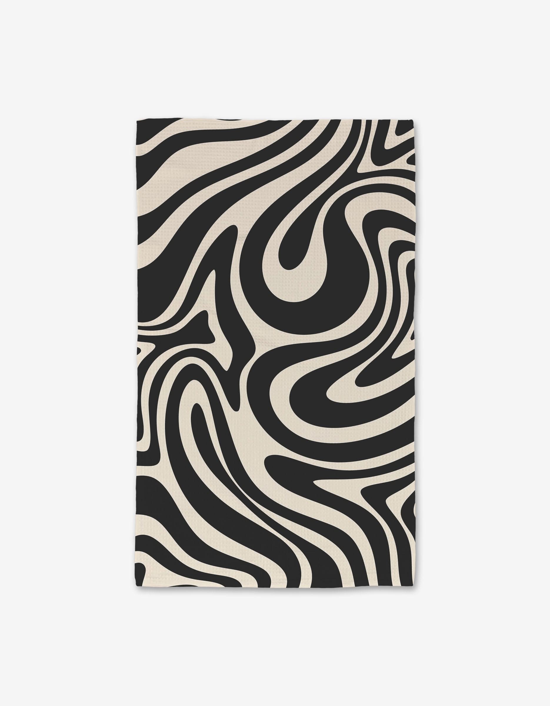 Rolling Retro hand towels by GEOMETRY feature an abstract black and cream wavy pattern on white fabric, and deliver ultra-absorbency with innovative Geoweave technology.