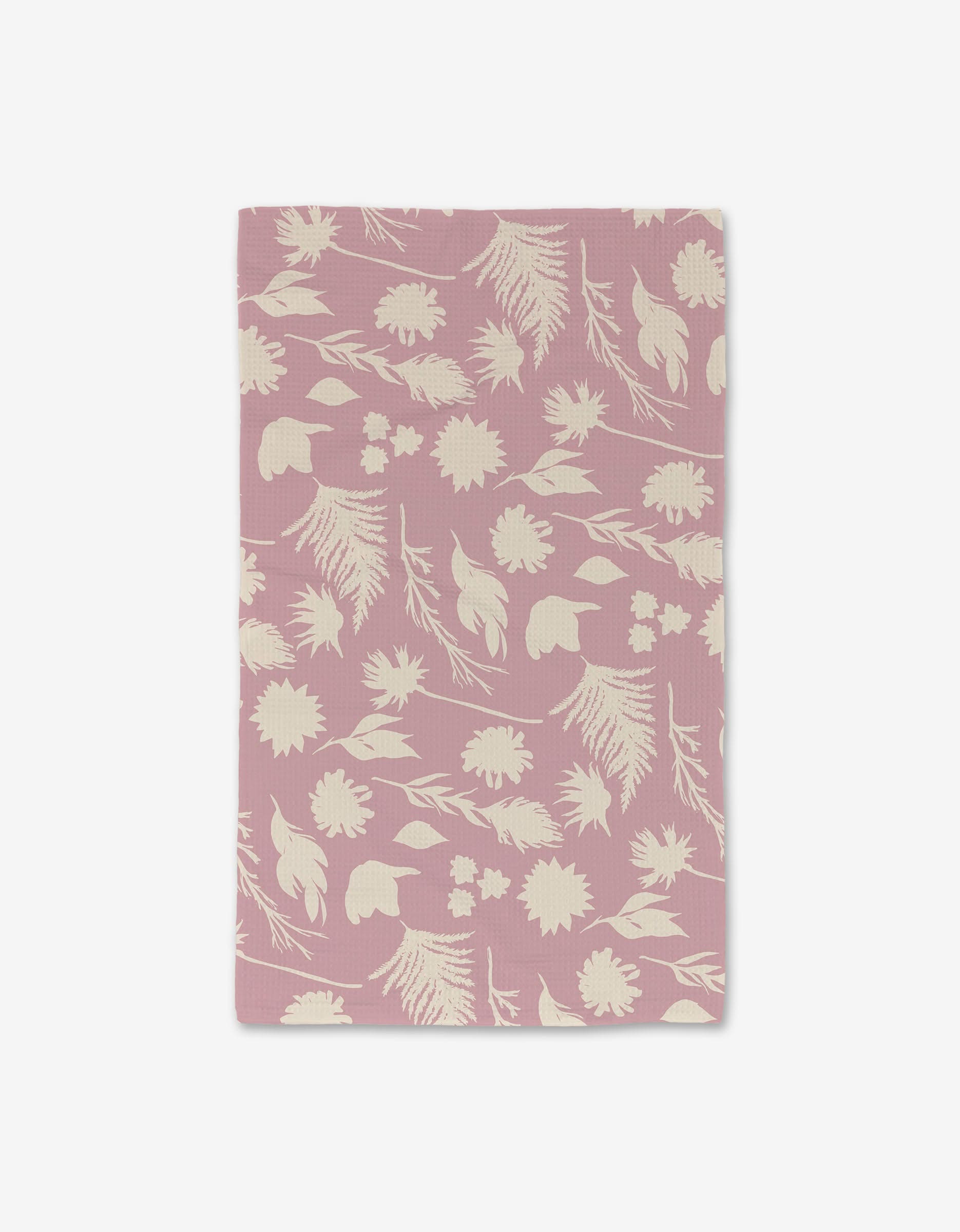 The GEOMETRY Silhouettes Luxe Hand Towel is a rectangular pink cloth with a white floral pattern, made with ultra-absorbent Geoweave technology, shown on a plain white background.