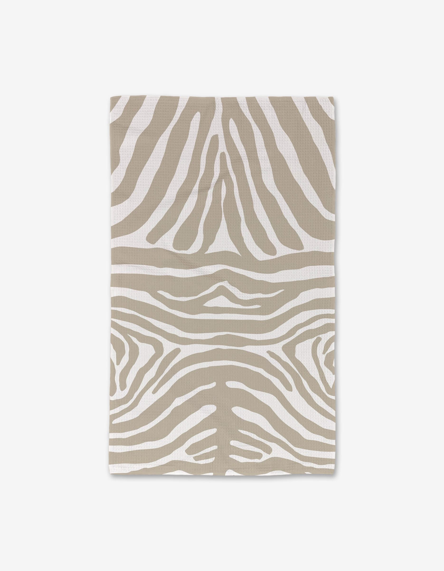 The GEOMETRY Zen Zebra is a rectangular hand towel with beige and white zebra stripes, shown flat on a white background. Crafted with Geoweave technology for ultra absorbency, it makes a stylish upgrade to your bath essentials.