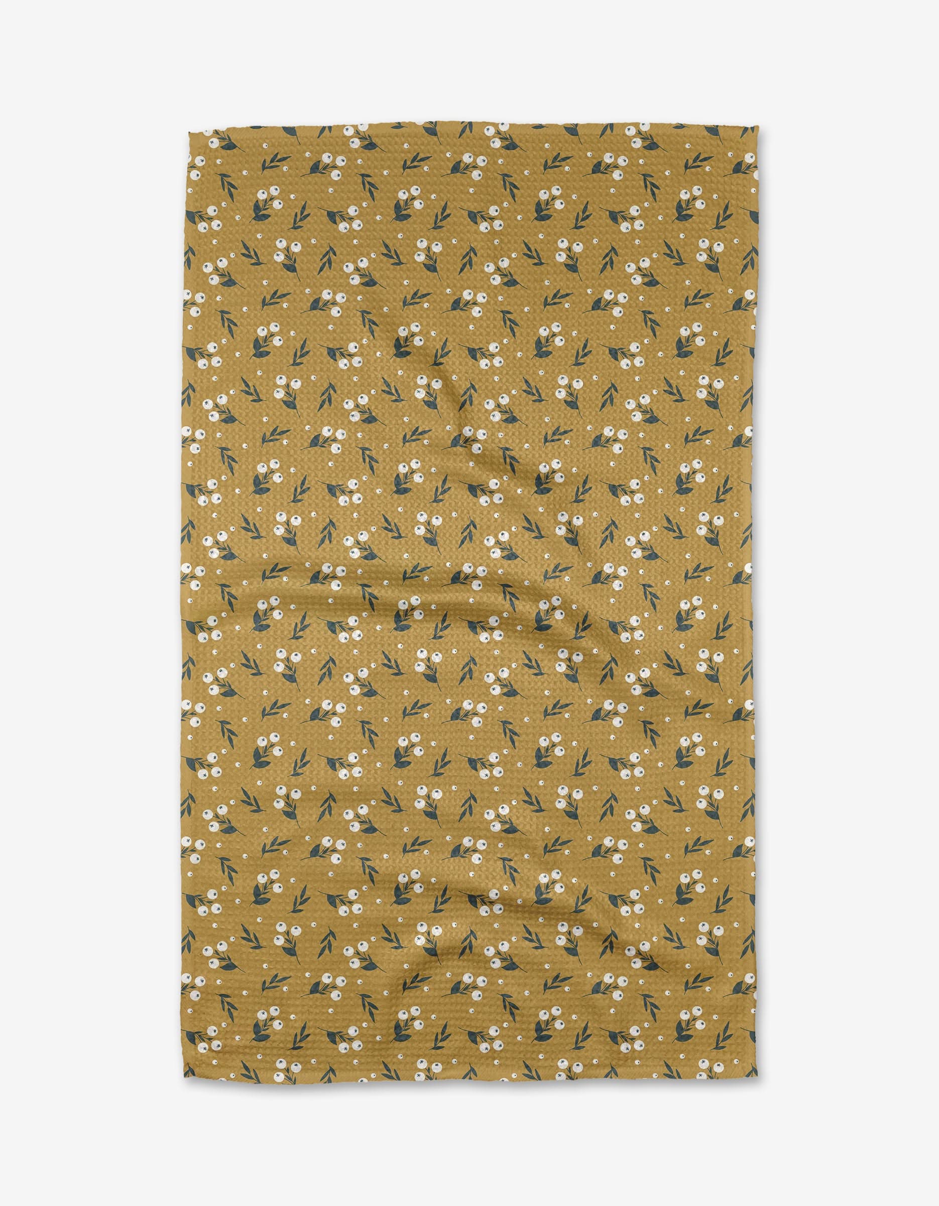 Betty by Charlie Rowan Designs is a mustard yellow Geoweave™ fabric with small white flowers and green leaves, shown flat against a white background with some visible creases.