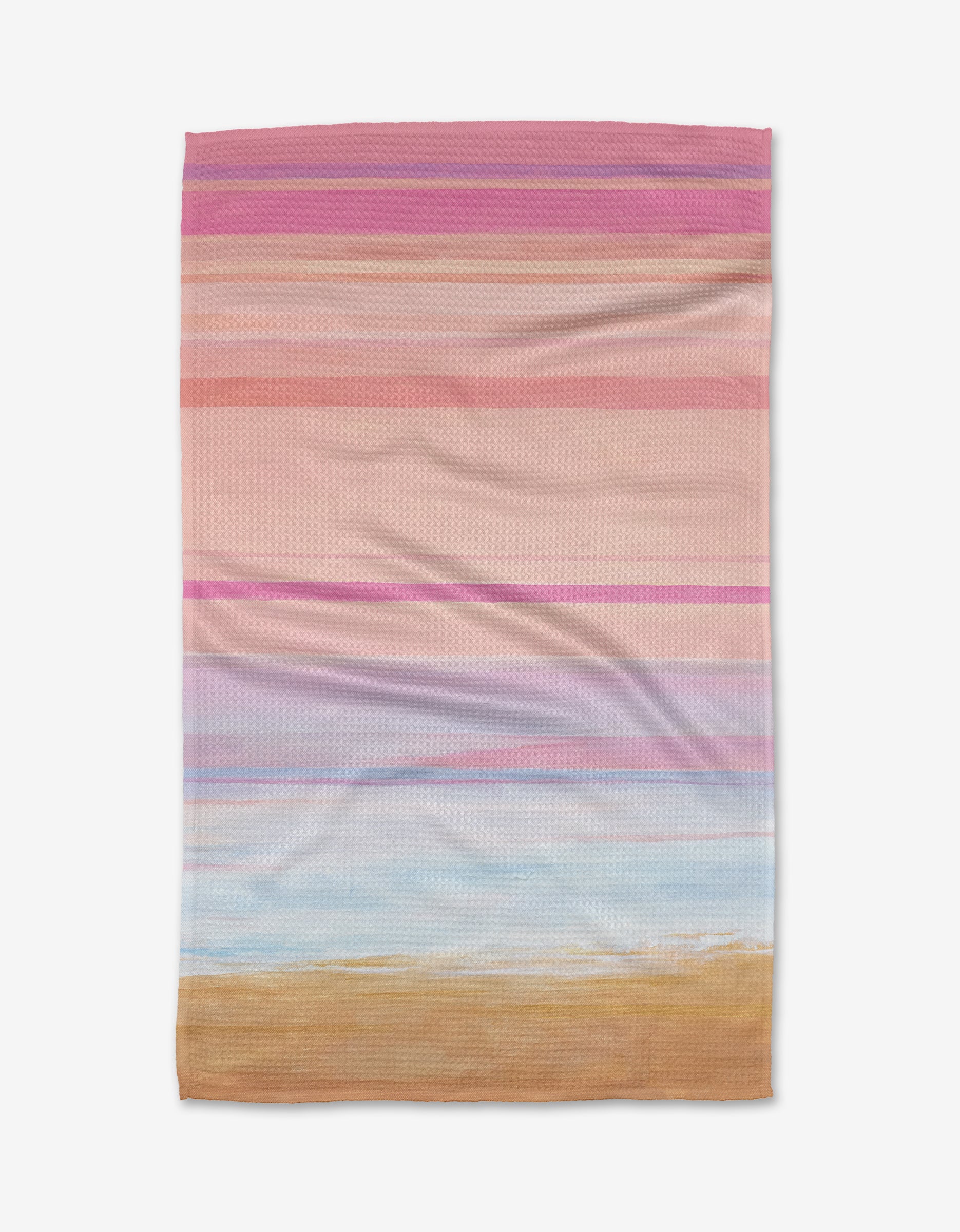 The Blush tea towel by Stefanie Bales features horizontal stripes in pink, purple, blue, and tan on Geoweave fabric, evoking a pastel beach scene. Shown laid flat on a white background.