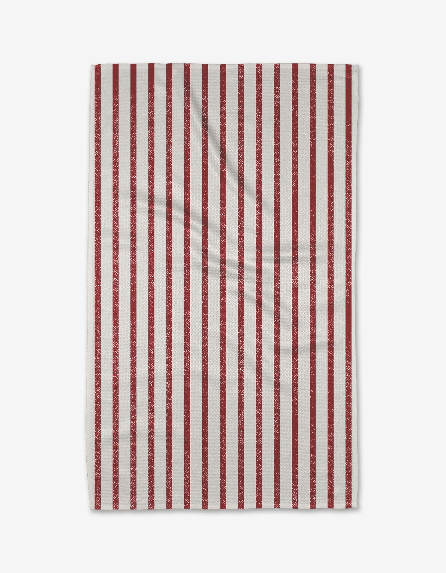 The Becki Owens Candy Cane tea towel, crafted from Geoweave fabric, features evenly spaced vertical red stripes on white and is shown flat against a white background.