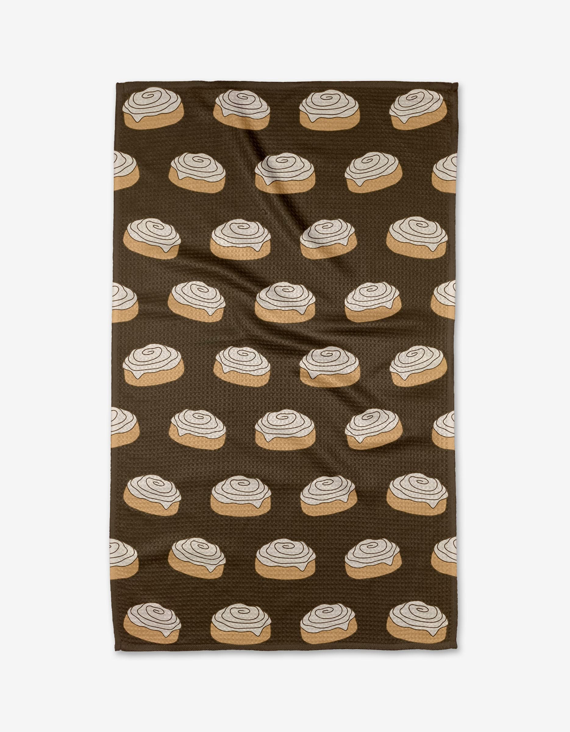 The Purely Kaylie Cinnamon Girl towel, made from ultra-absorbent Geoweave fabric, showcases a repeating print of cinnamon rolls with white icing across its brown surface.