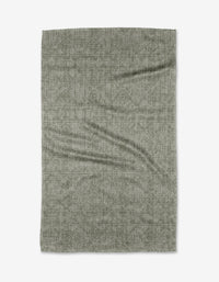 The Debra Sage tea towel by Becki Owens is a rectangular, textured gray piece made from recycled materials, shown laid flat on a white background with visible creases and folds.