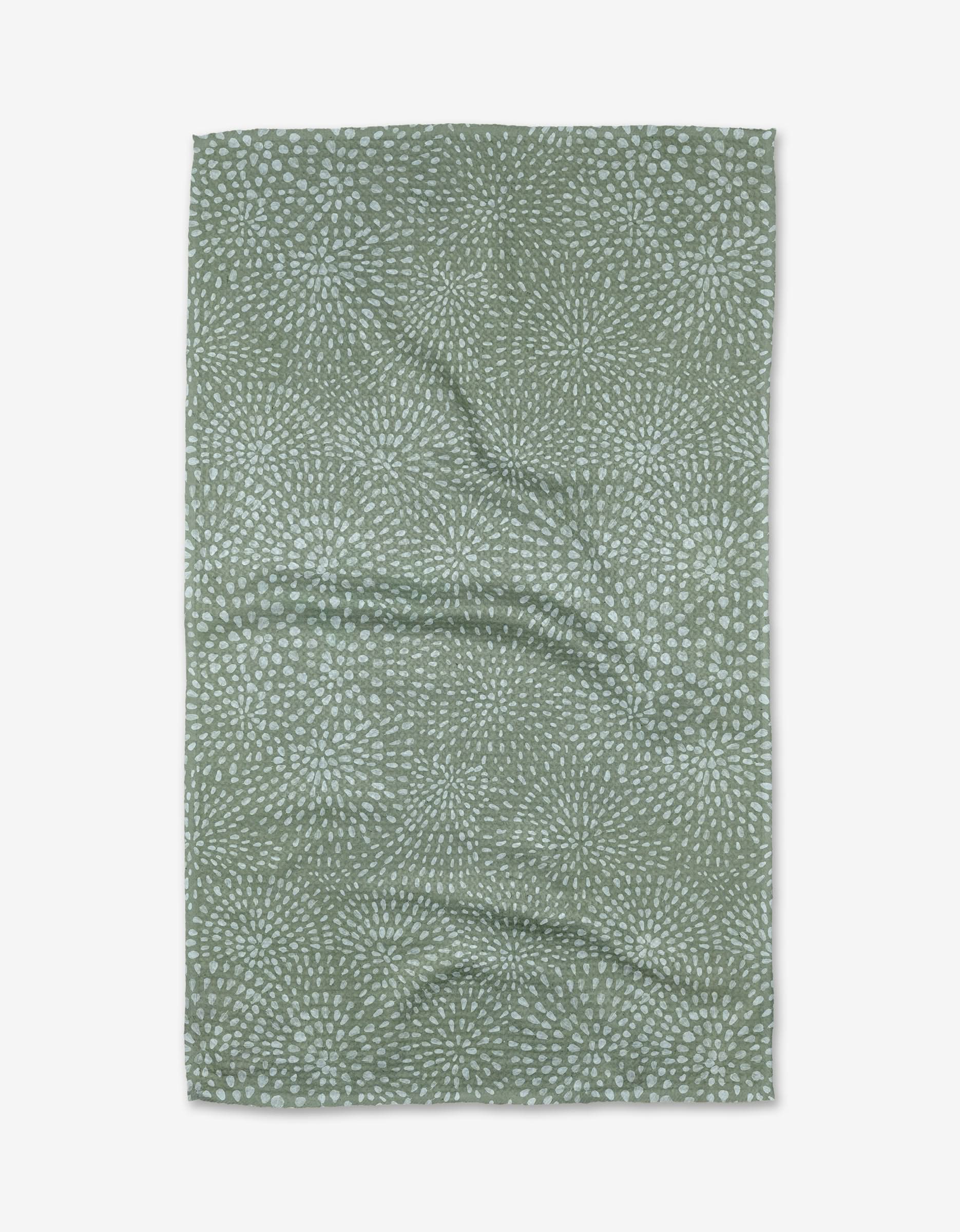 The Katie OShea Droplets tea towel features a green Geoweave™ fabric with small, light blue dot clusters for a textured look. Made from recycled materials, the rectangular towel is displayed slightly wrinkled on a white background.