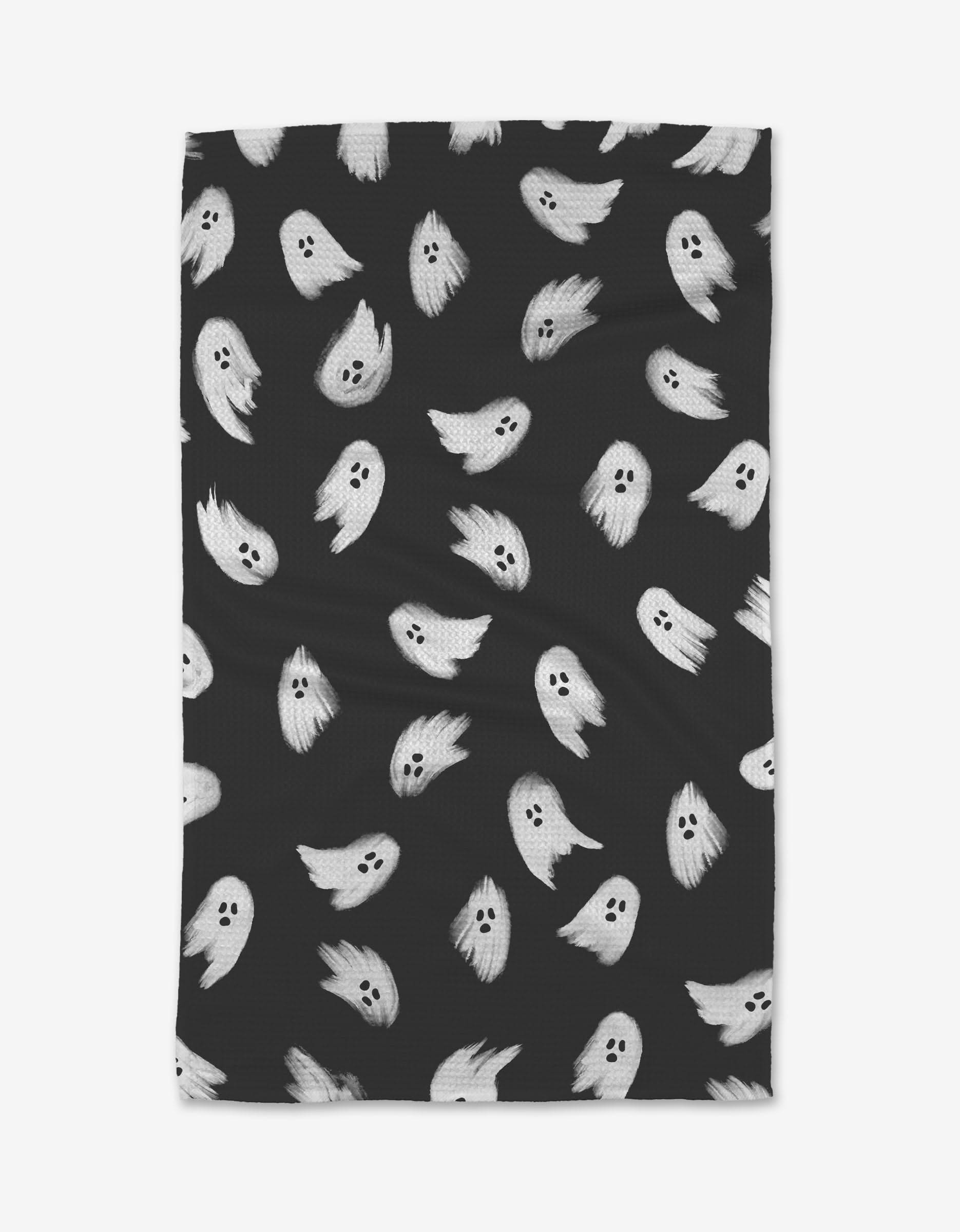 The GEOMETRY Ghosted blanket is black with a playful pattern of small white cartoon ghosts, each with expressive faces. Made from recycled materials, its an eco-friendly and stylish choice.