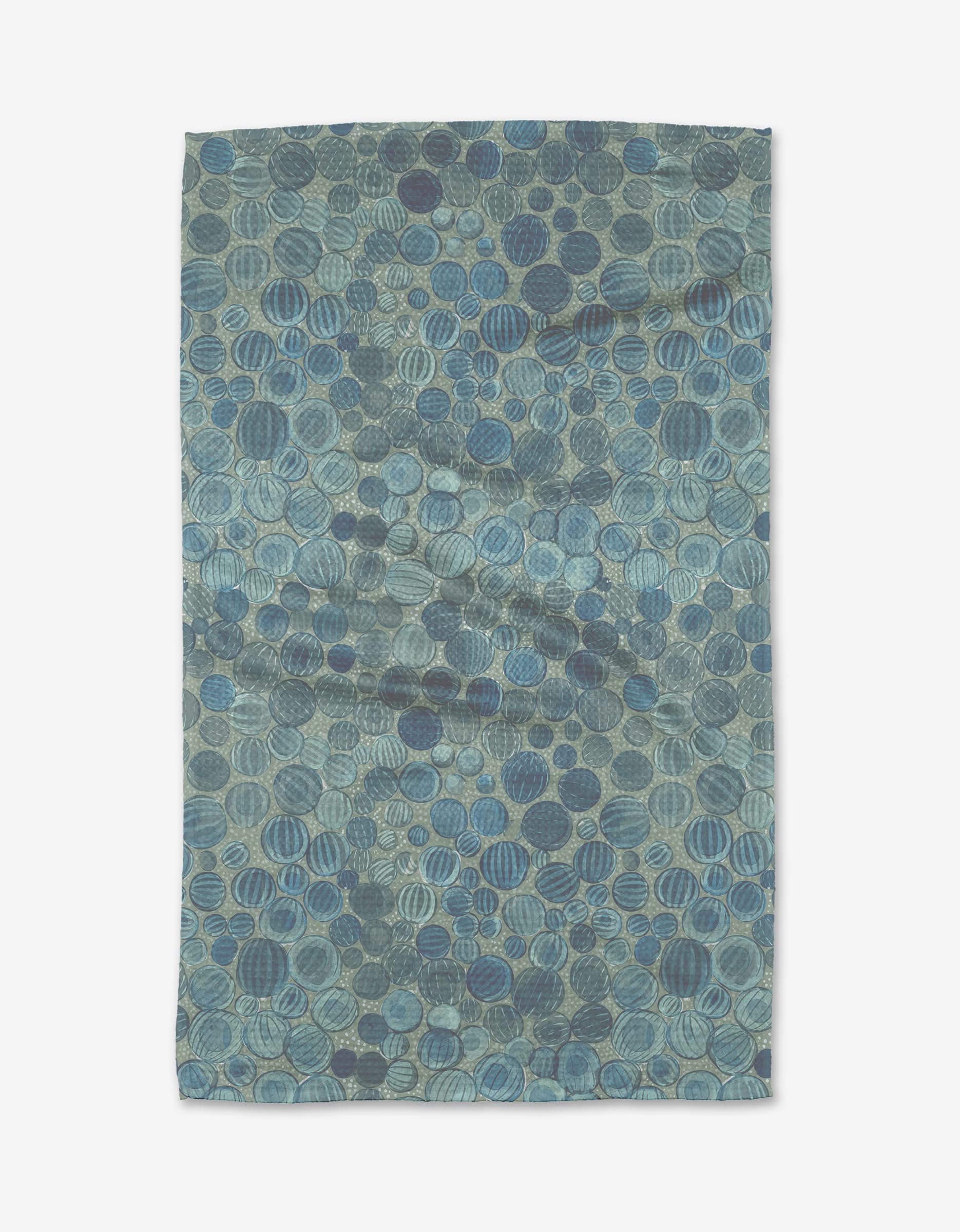 The Katie OShea Glass Baubles rug features blue and green overlapping circular shapes in varied shades and textures, crafted from post-consumer recycled materials for a richly textured, abstract look.