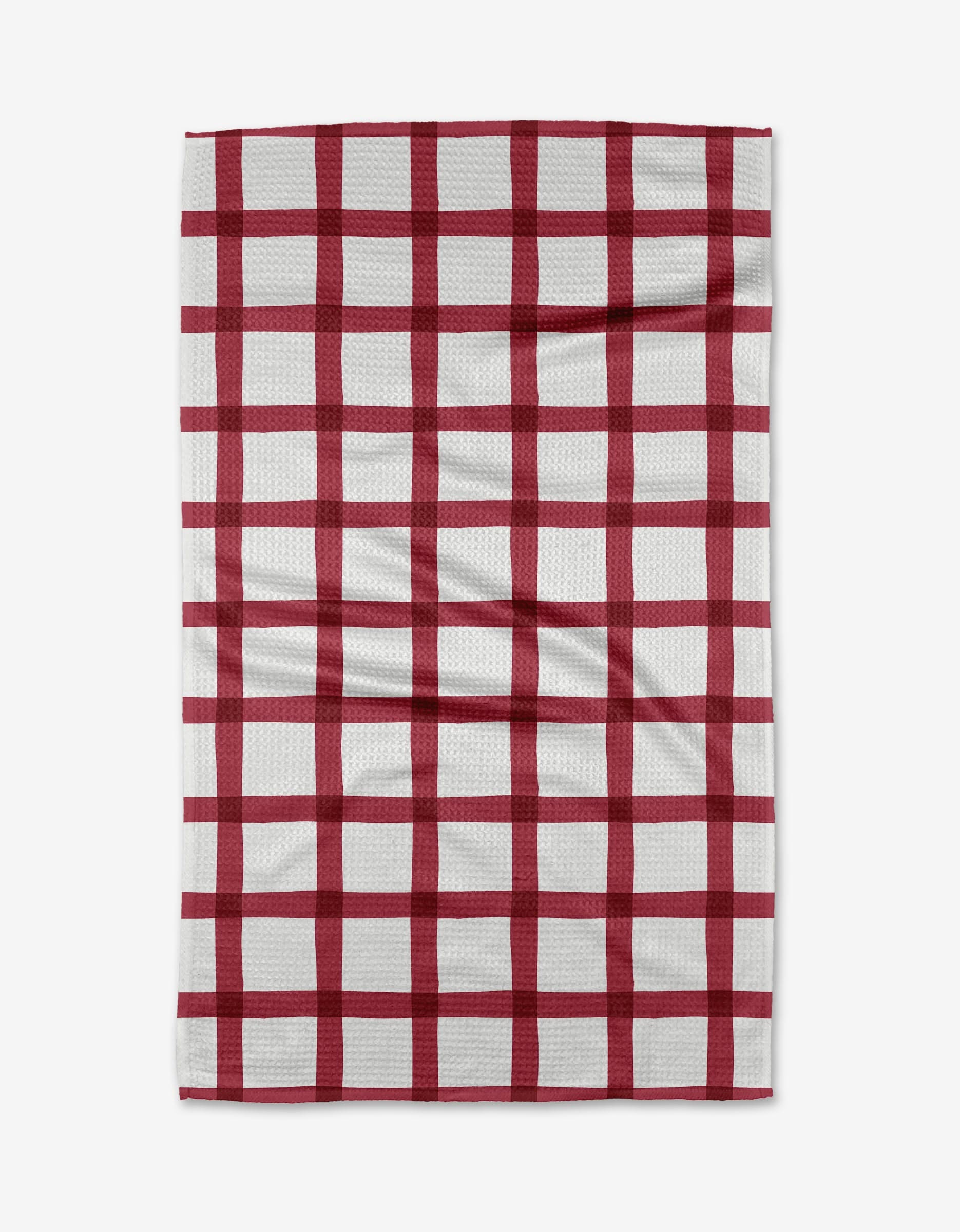 The Hackett tea towel by Amy MacCready features a white background with a red checkered grid, laid flat with slight wrinkles. Made from soft Geoweave fabric, it offers enhanced absorbency for everyday use.