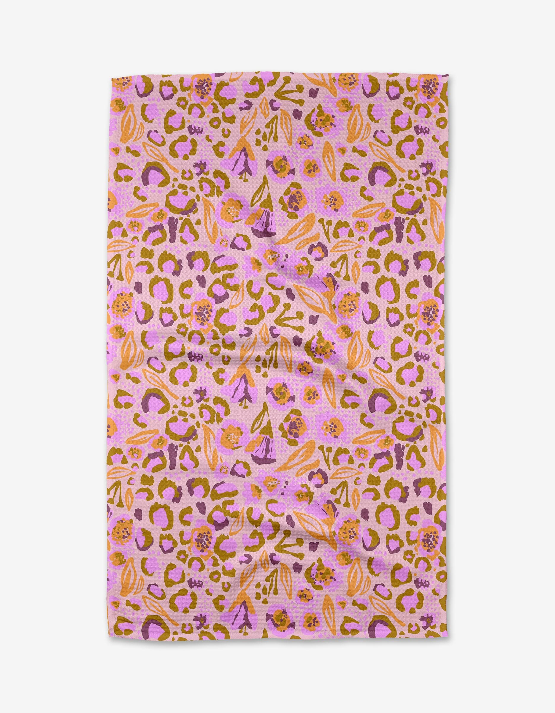 Leopard Loving by Elisabeth Wing is a rectangular Geoweave fabric with a pink background, abstract orange, yellow, and purple leopard spots, and floral motifs. The ultra-absorbent fabric is shown flat with visible folds.