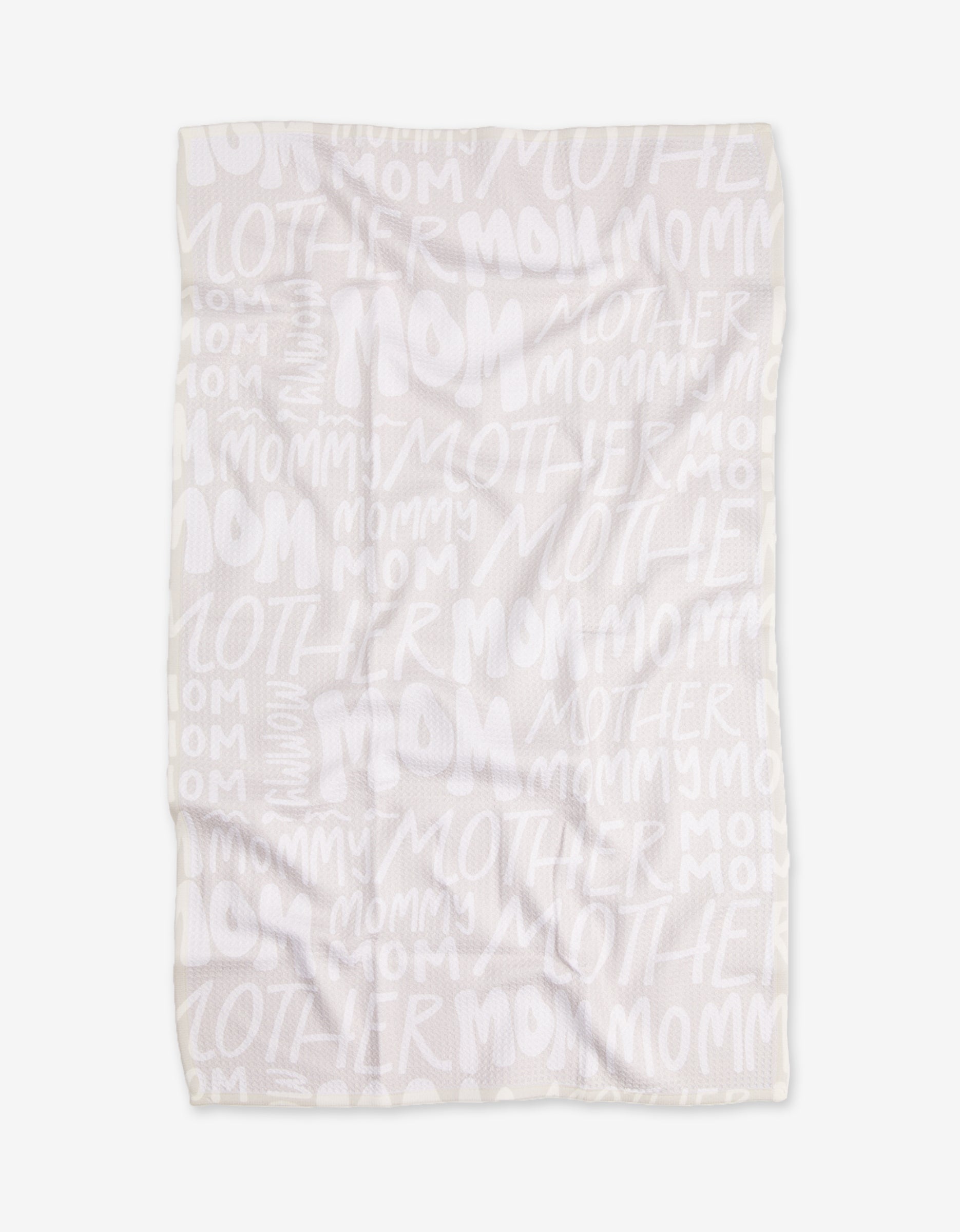 The GEOMETRY Mom blanket features white Geoweave fabric with repeated words MOM, MOTHER, and MOMMY in varied sizes and fonts in a light, semi-transparent print. The blanket is shown flat with some visible wrinkles.