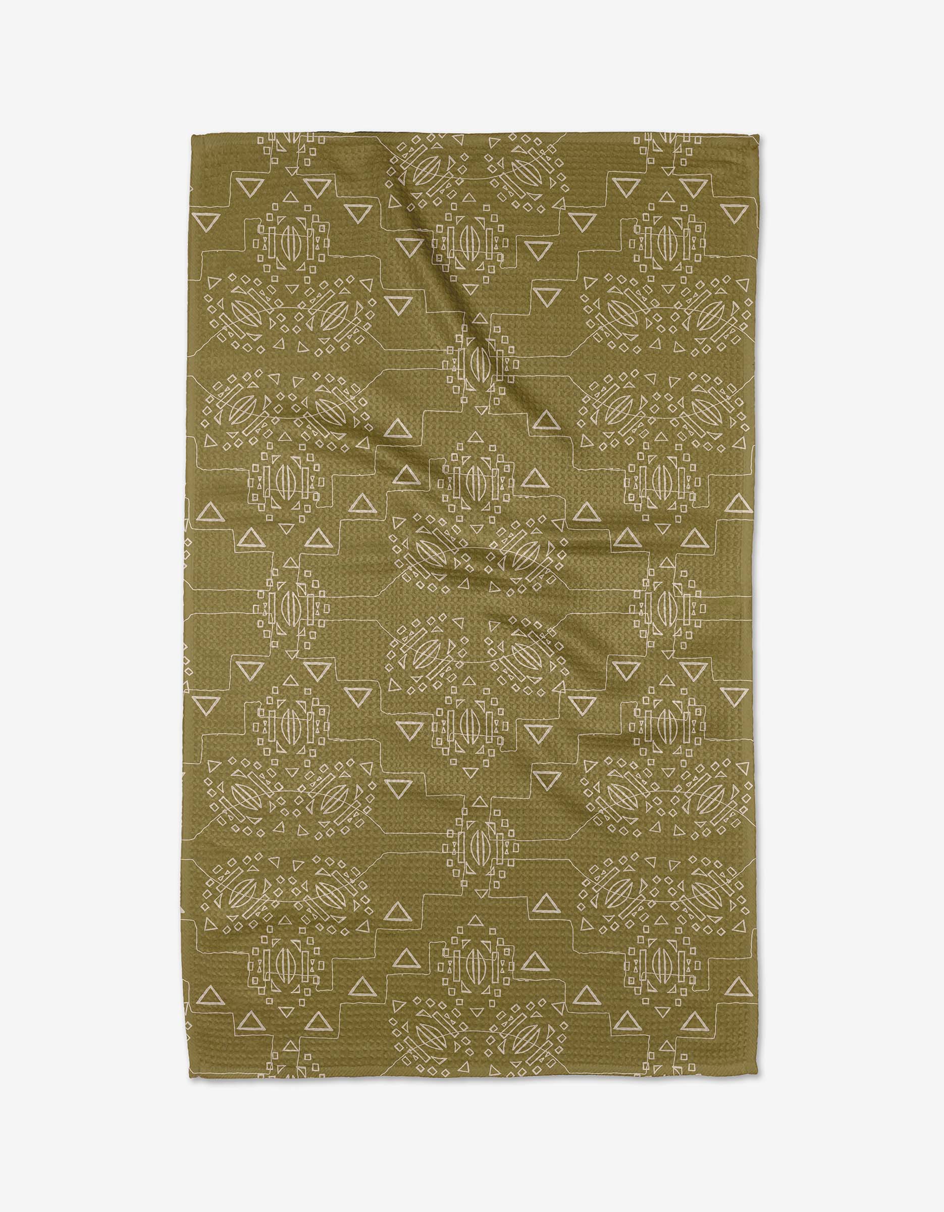 The Ash Cascade Mountain Bloom tea towel is rectangular, olive green, made from recycled materials, and features a symmetrical white geometric and tribal-inspired pattern. It is shown flat with visible creases.
