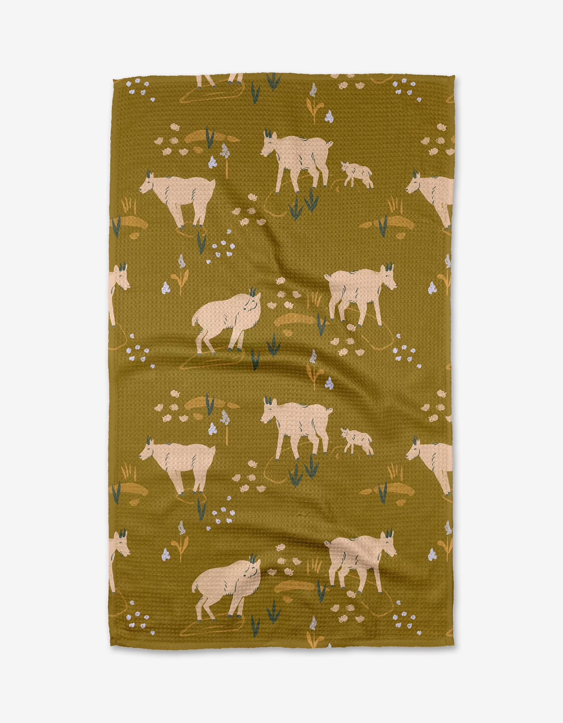 The Mountain Goats tea towel by Mandy Arroyo features brown-green Geoweave fabric with illustrated goats grazing among white flowers and green plants, made from recycled materials.