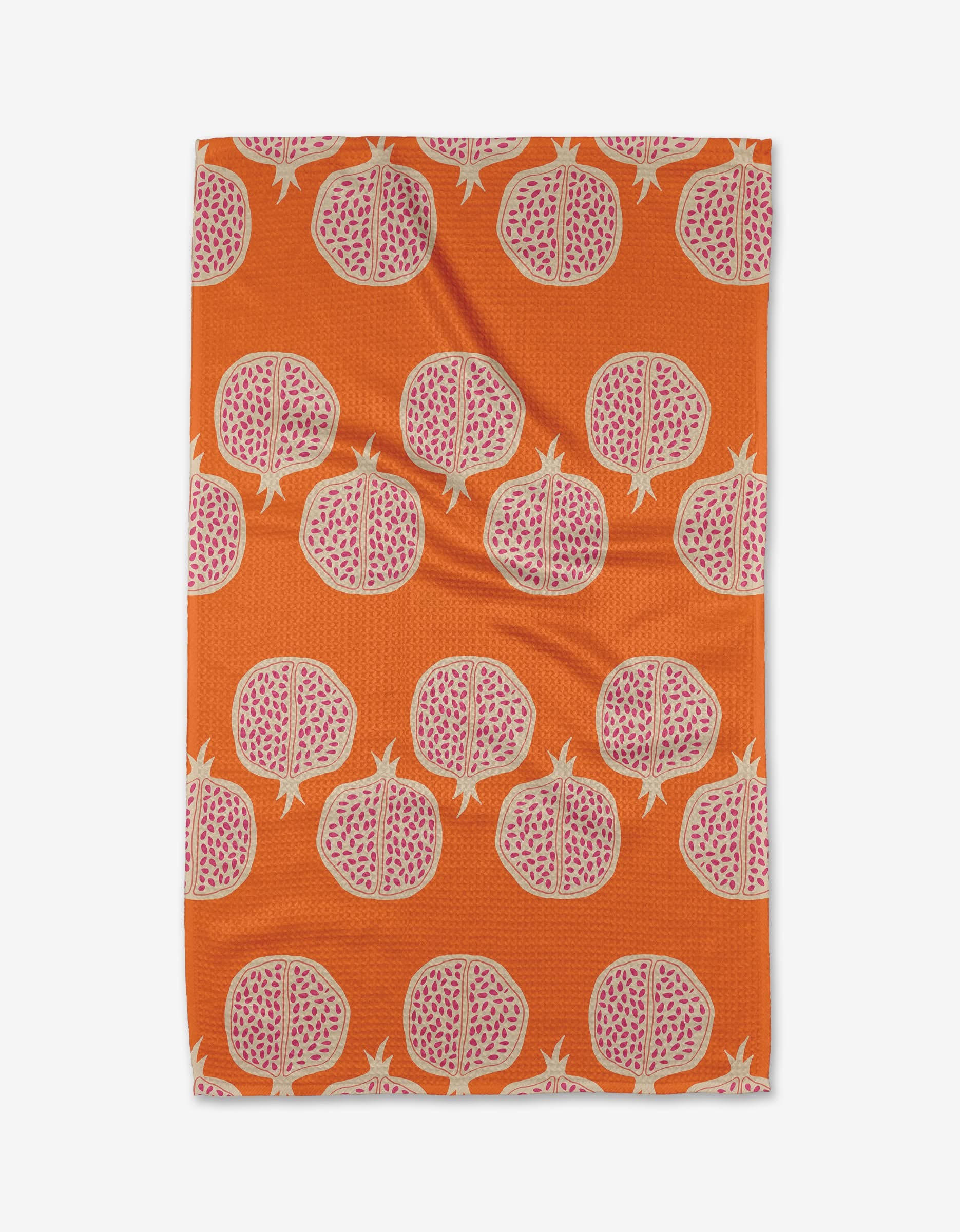 The Pomegranate Parade tea towel by Lizzie Clark is rectangular, ultra-absorbent, and made from recycled materials, featuring an orange backdrop with a repeating pattern of pink pomegranate halves and visible seeds.