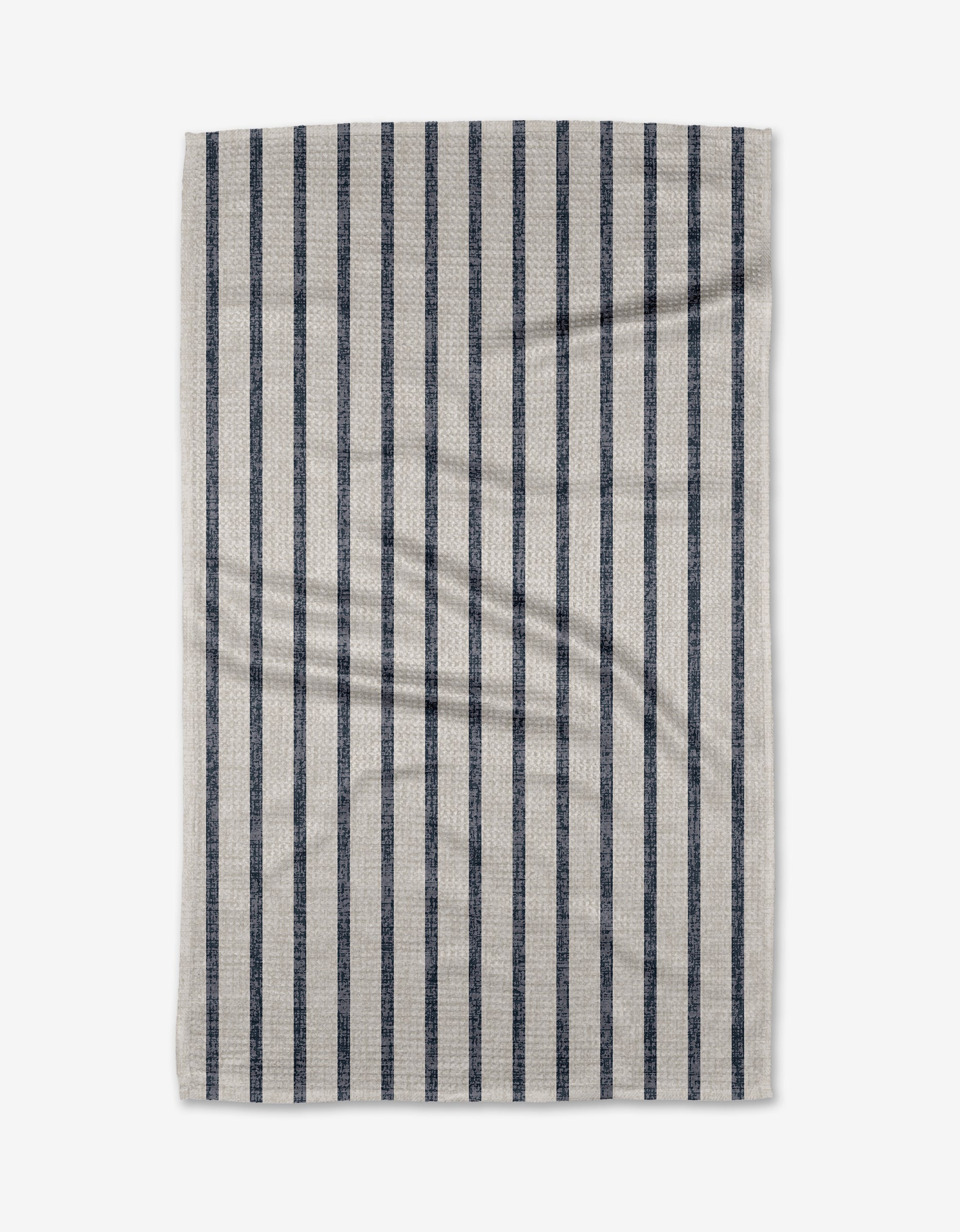 A rectangular beige Becki Owens Ren Blue tea towel, made from ultra-absorbent Geoweave fabric, features evenly spaced dark blue vertical stripes and subtle wrinkles, displayed flat on a white background.