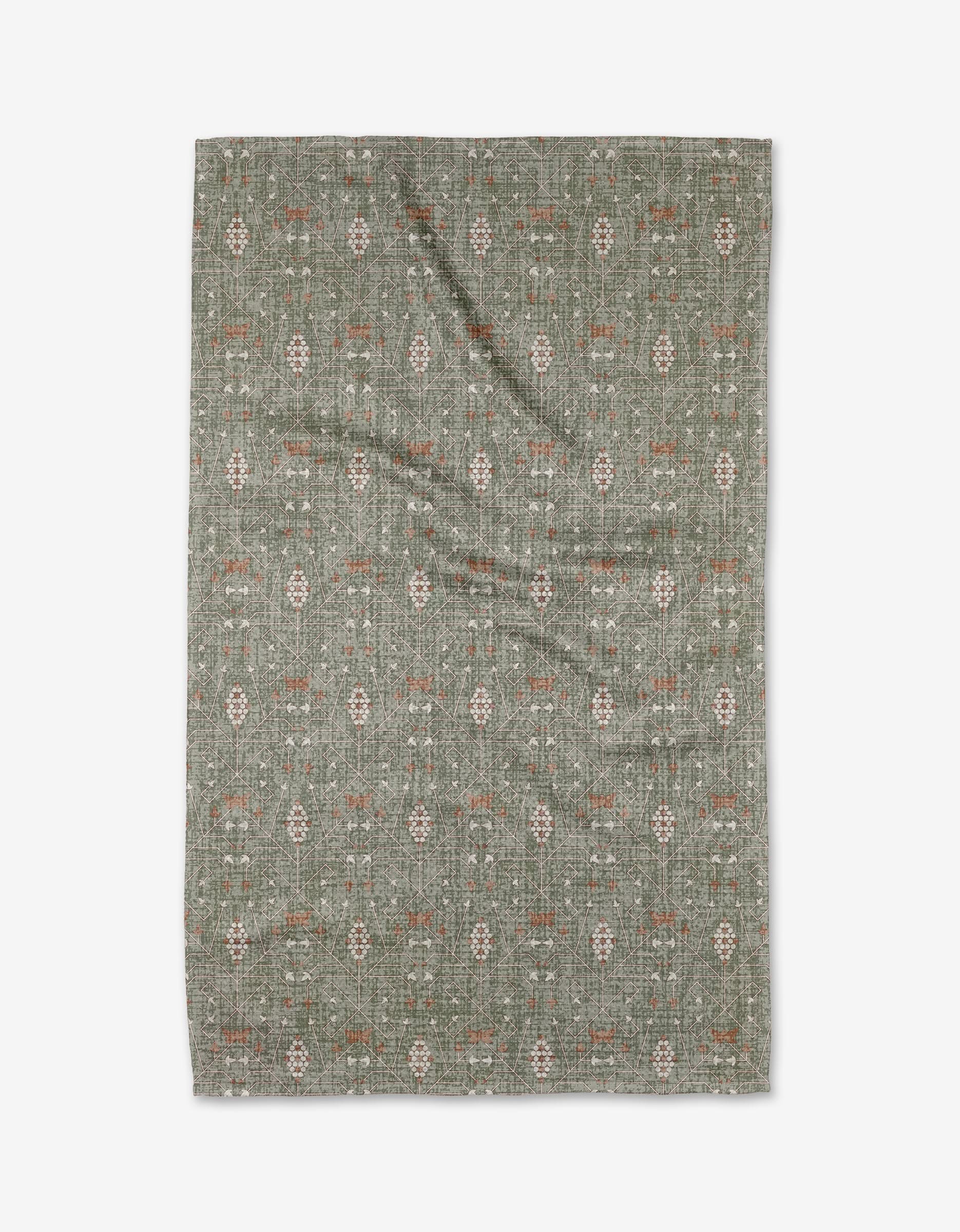 The Rulon Sage rug by Becki Owens is a rectangular green mat made from ultra-absorbent Geoweave fabric, featuring subtle cream and rust geometric and floral patterns, displayed flat on a white background.