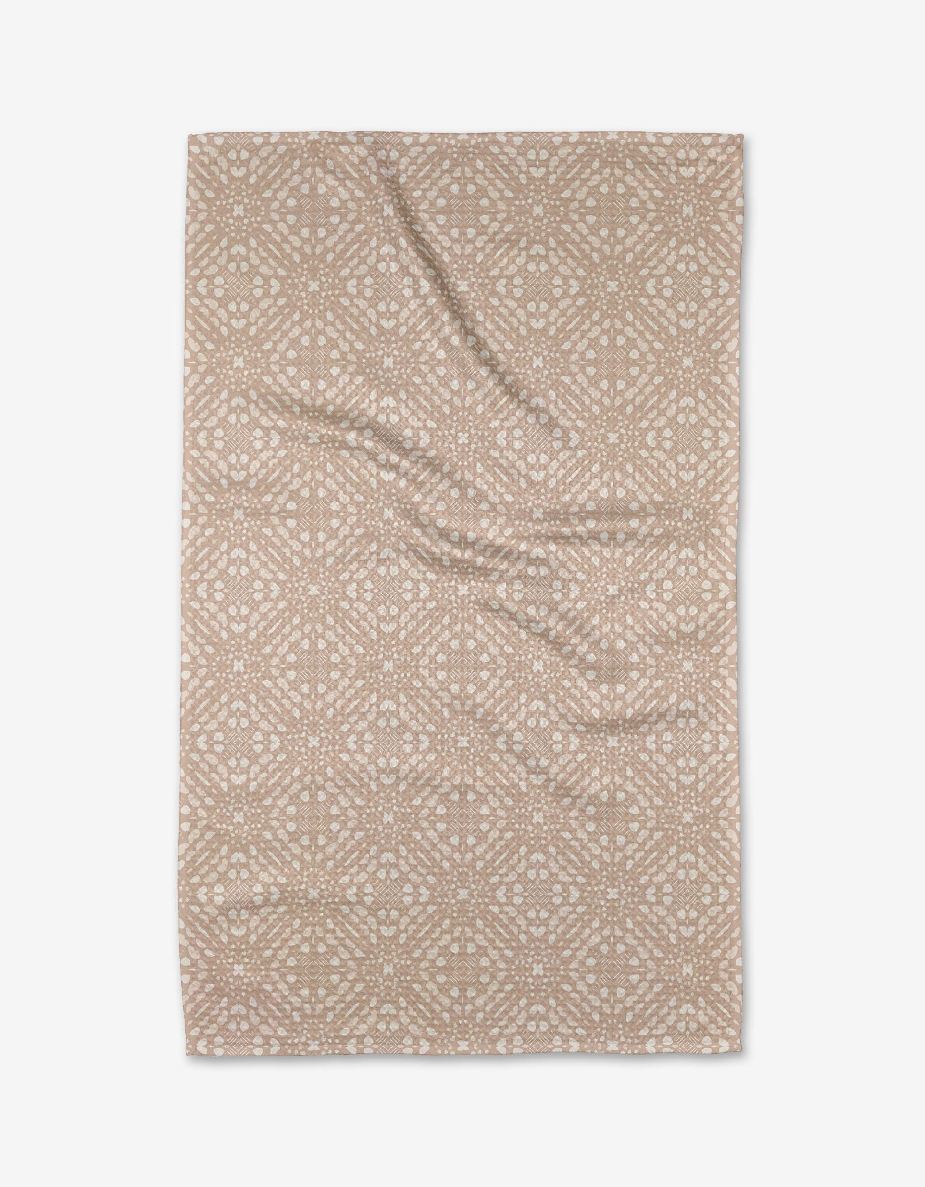 Seeds and Nuts Neutral by Twig + Spark: a beige rectangular tea towel featuring a white geometric and floral print. Made from soft recycled materials, the fabric is slightly wrinkled and shown flat on a white background.
