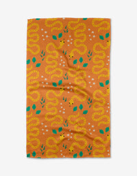 Add vibrant charm to your kitchen with Genna Blackburns Snakes tea towel, featuring yellow snakes, green leaves, and white stars on a solid orange background. Quick-drying and stylish—a must-have kitchen essential.