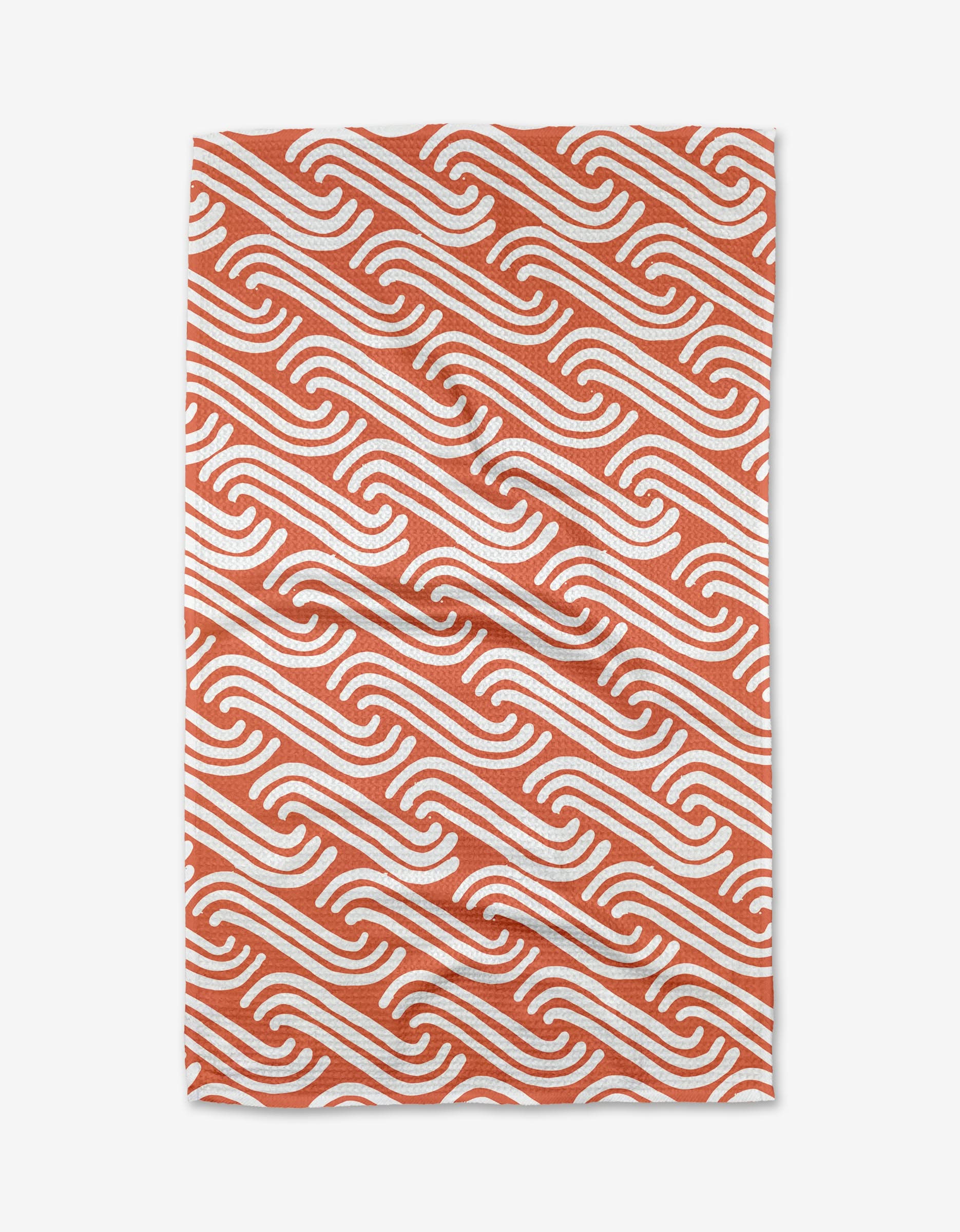 The Spirited rug by Sissy Moon features a rectangular shape with white diagonal wave patterns on a terracotta orange base. Crafted from recycled materials, its dynamic design brings movement to any space.