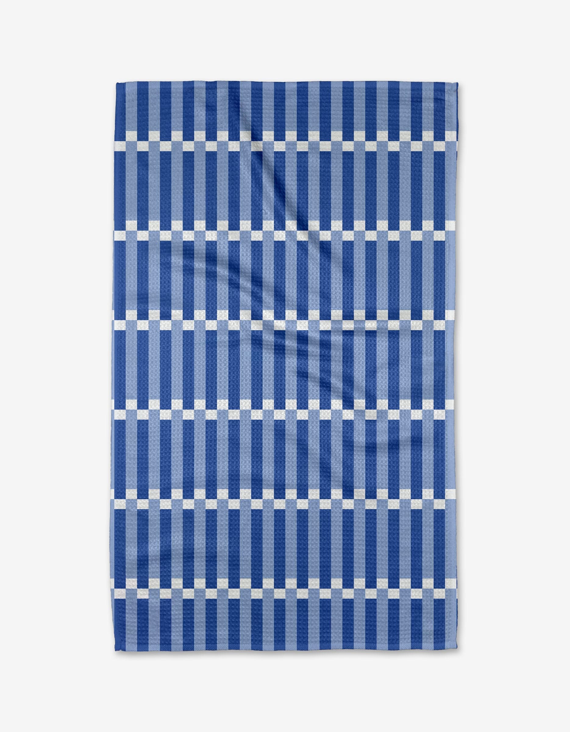 The Buy Guides Stripe Block - Blues is a kitchen tea towel made from recycled materials, featuring a geometric grid of dark blue stripes and white lines. The towel is shown flat with a few visible creases.