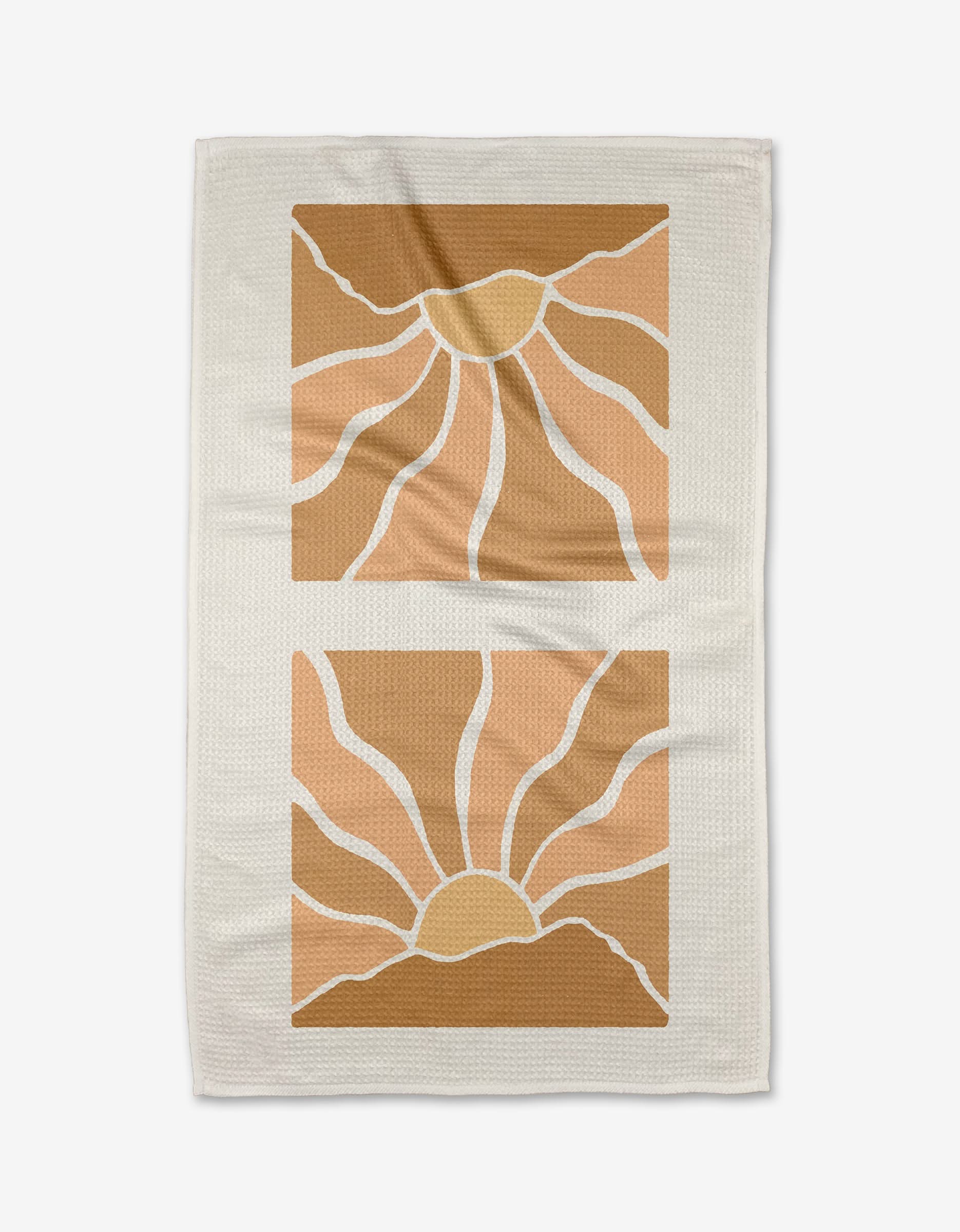 Graphics and Grain’s Sun Rays kitchen towel is beige and features two geometric suns in warm yellow, orange, and brown tones with wavy rays in stacked square frames. Made from recycled materials.