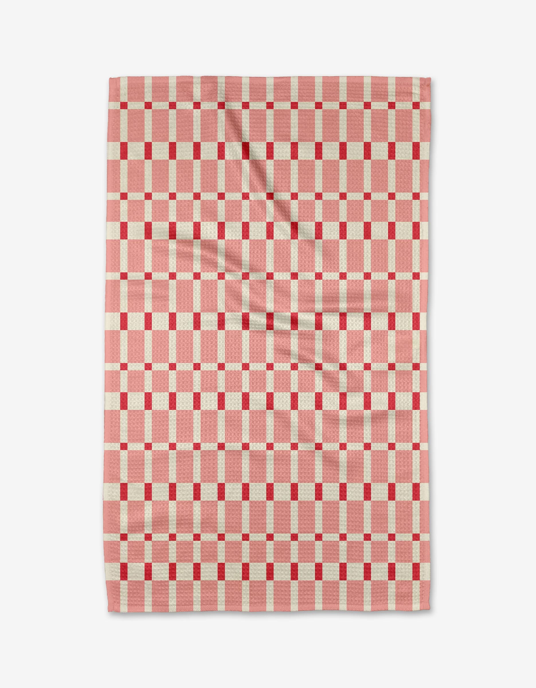 The Sweet Tooth Tea Towel by Rebecca Woolbright is rectangular with a red and white checkered grid of small squares and lines. Made from Geoweave™ fabric, it shows soft creases and is displayed on a white background.