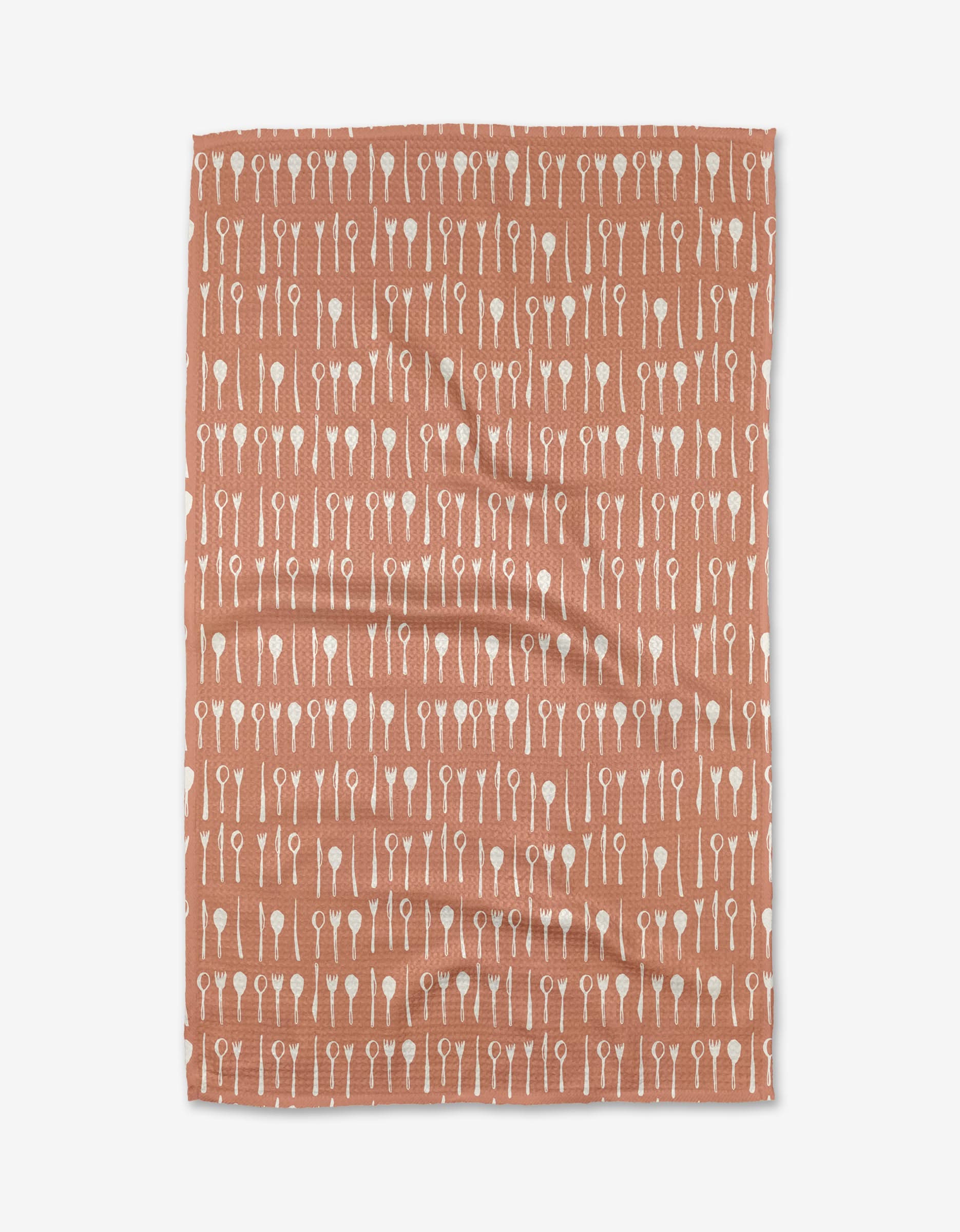 The Tableware tea towel by Anee Shah features a rust hue and is made from Geoweave fabric, with a white utensil pattern—forks, knives, and spoons—displayed in neat horizontal rows.