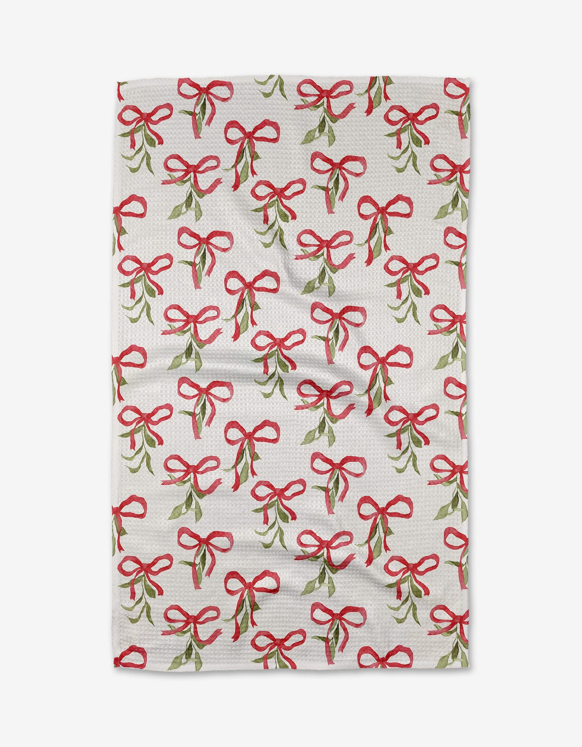 The Tied Up With Bows recycled kitchen towel by Aubrey Fairchild features an all-over pattern of green mistletoe sprigs tied with red bows, evenly spread across a white background.