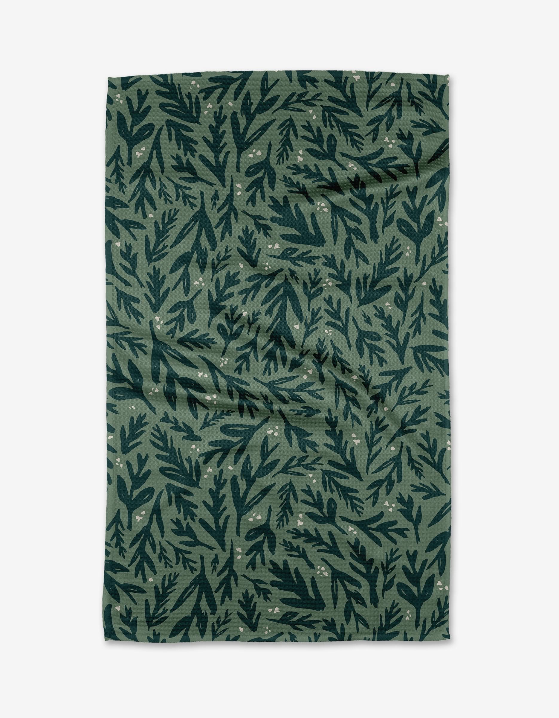 The Twig + Spark Trail Dusting green tea towel, crafted from eco-friendly Geoweave™ fabric, features a dark green leafy pattern with small pale dots and is displayed flat on a white background.